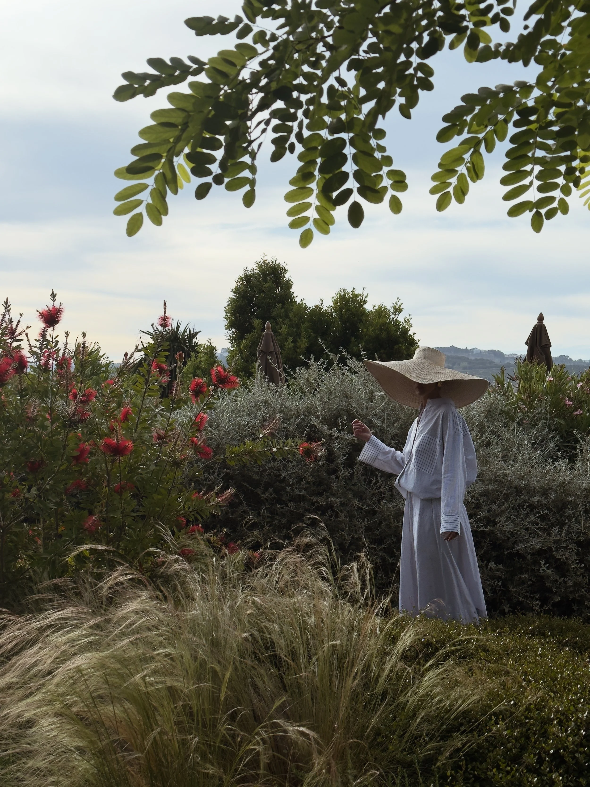 Woman walking through the Mediterranean gardens at Finca La Marquesa, a luxury holiday home surrounded by olive groves near Ronda, Andalusia, Spain.