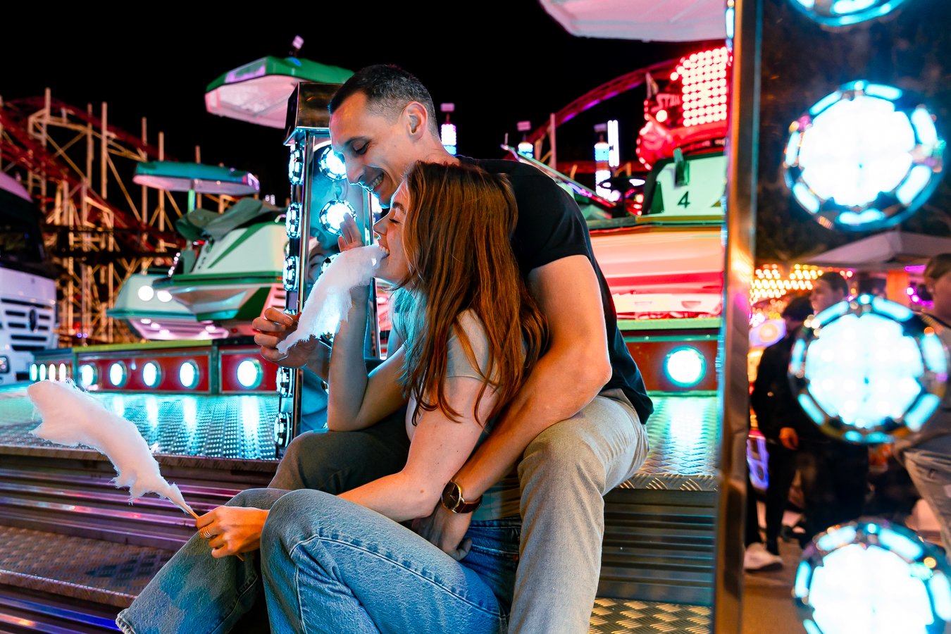 couple assis sur les marches d'un manège qui partage une barbe à papa, photographe mariage Grenoble