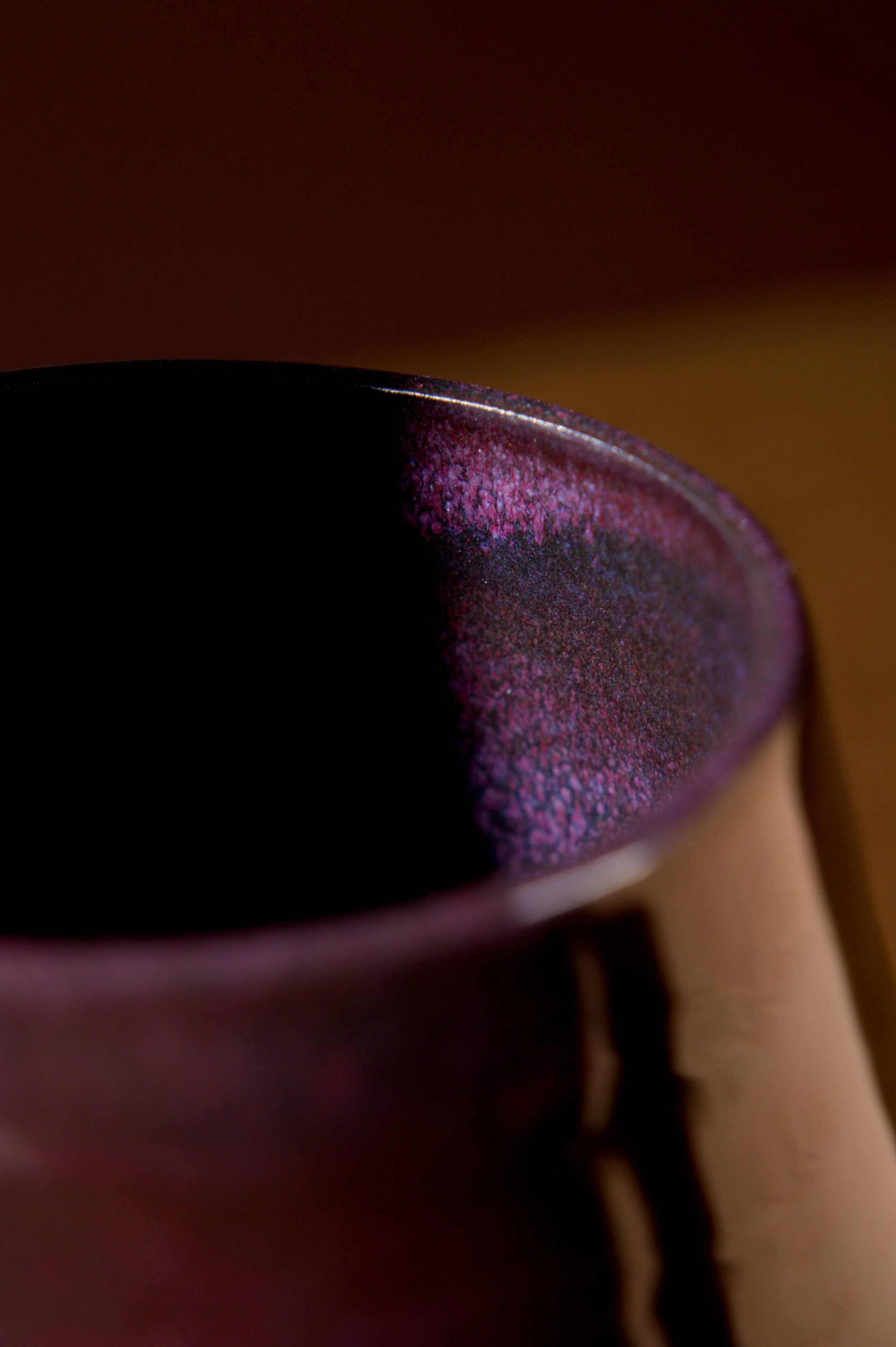 Un détail de l'émail d'un verre à bière violet avec une surface texturée, photographie en gros plan.