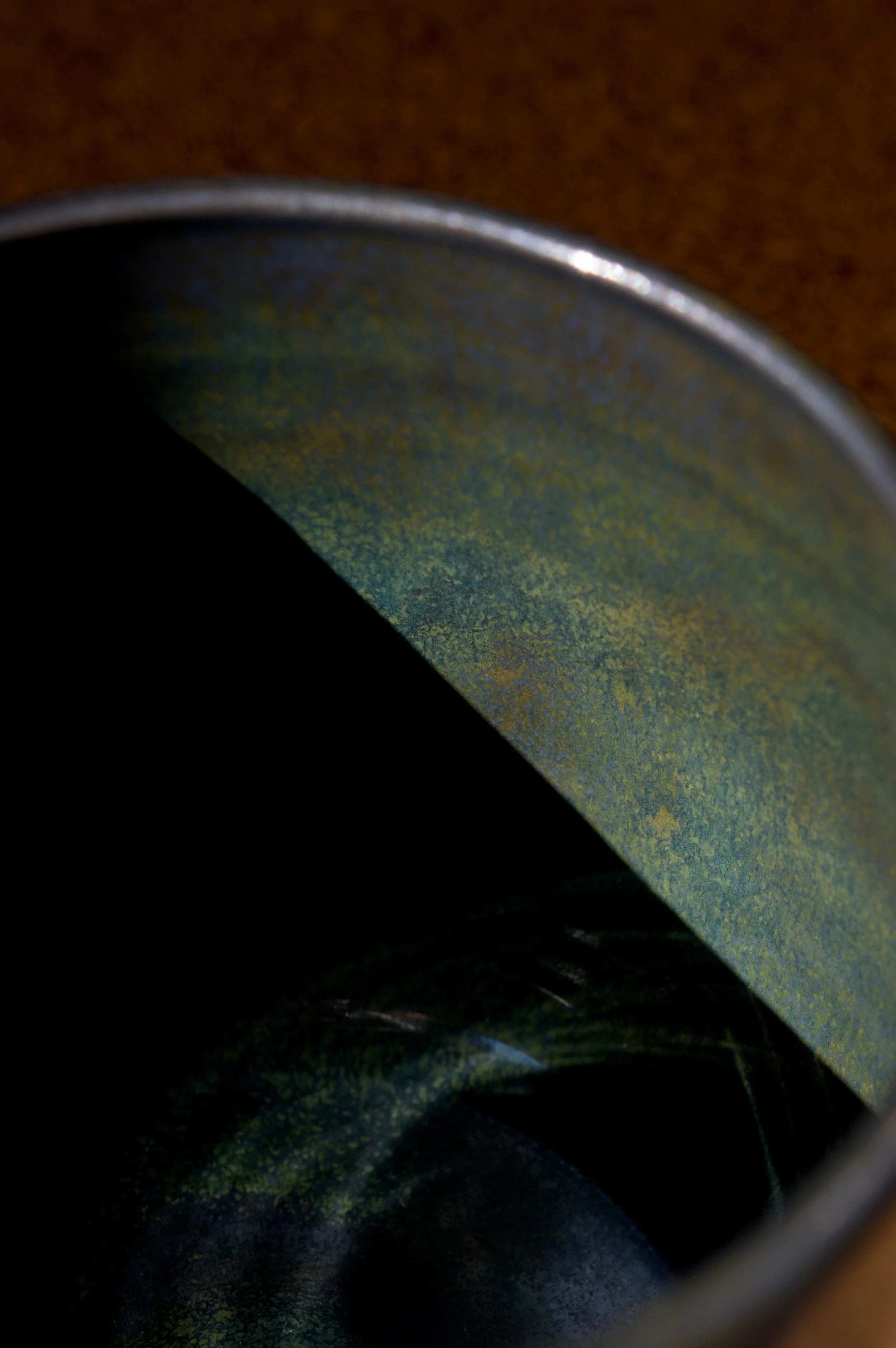 Gros plan sur une surface émaillée avec une texture verte et une bords arrondis.