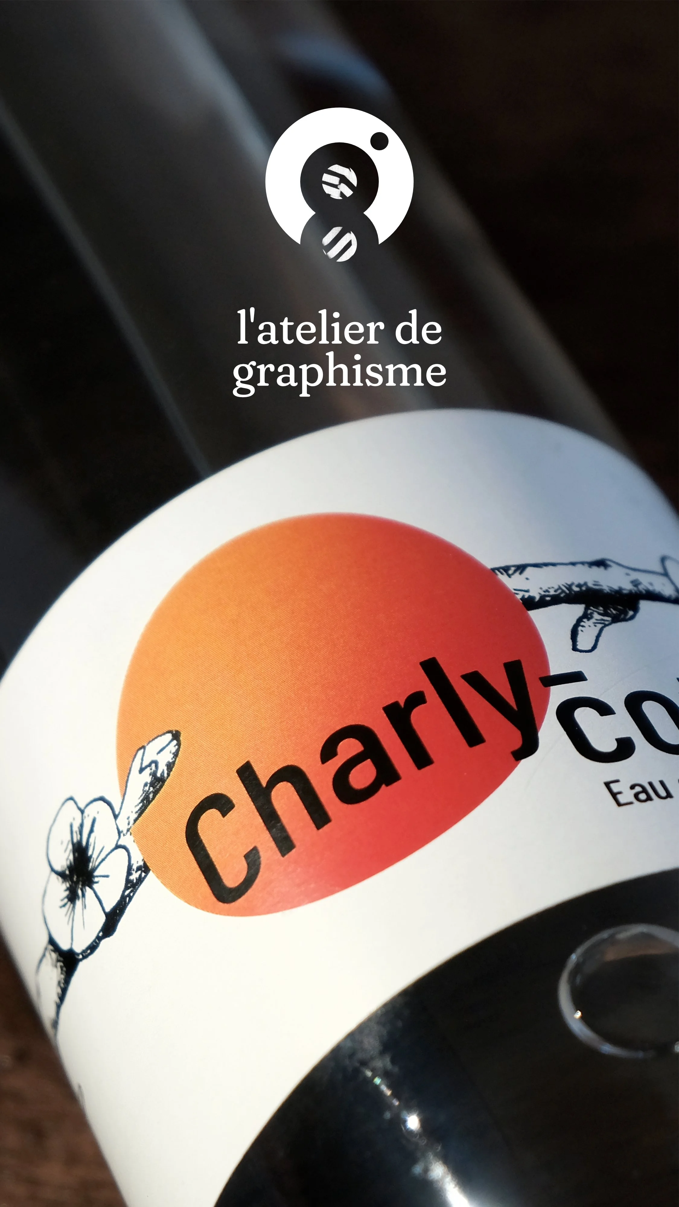 Une bouteille de parfum avec une étiquette 'Charly' et un dessin de fleur.