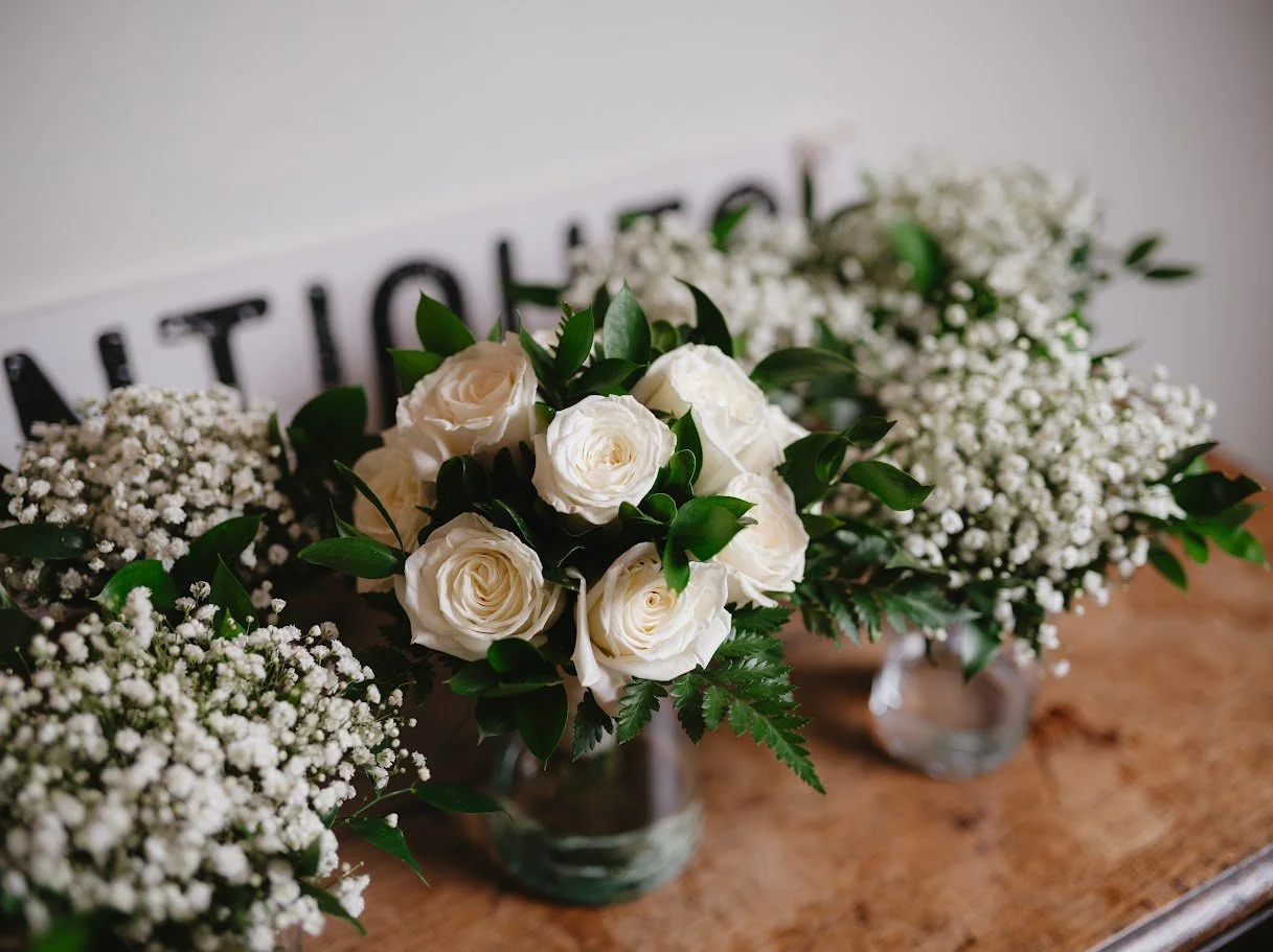 A bouquet of various flowers including pink, white, and red roses, baby's breath, and greenery.