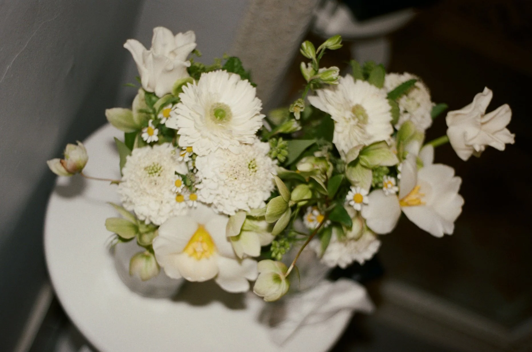 White bouquet of various flowers on a table.
