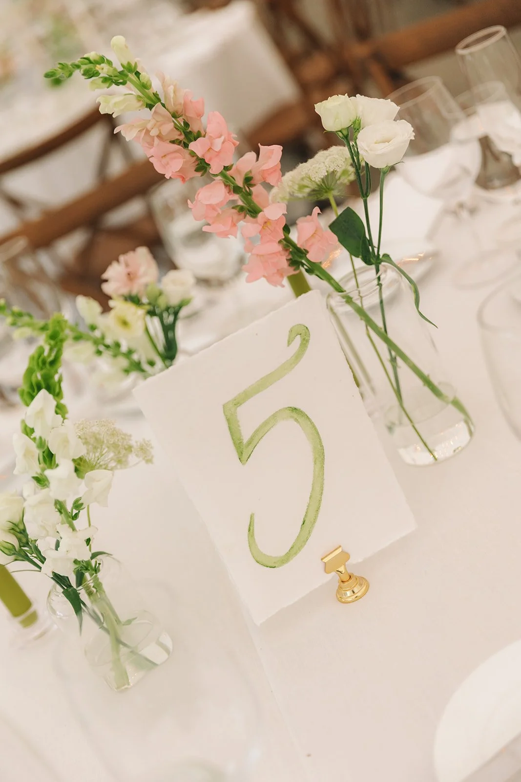Table number 25 with floral centerpieces in glass vases at a wedding reception.