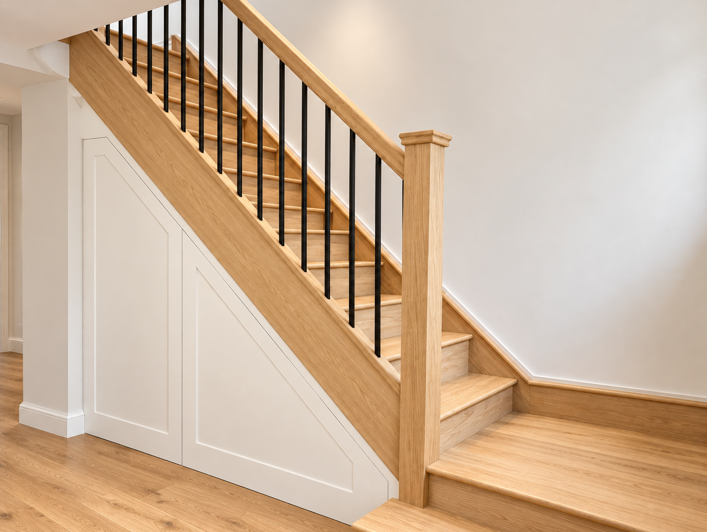 Oak staircase with black metal spindles and understairs storage