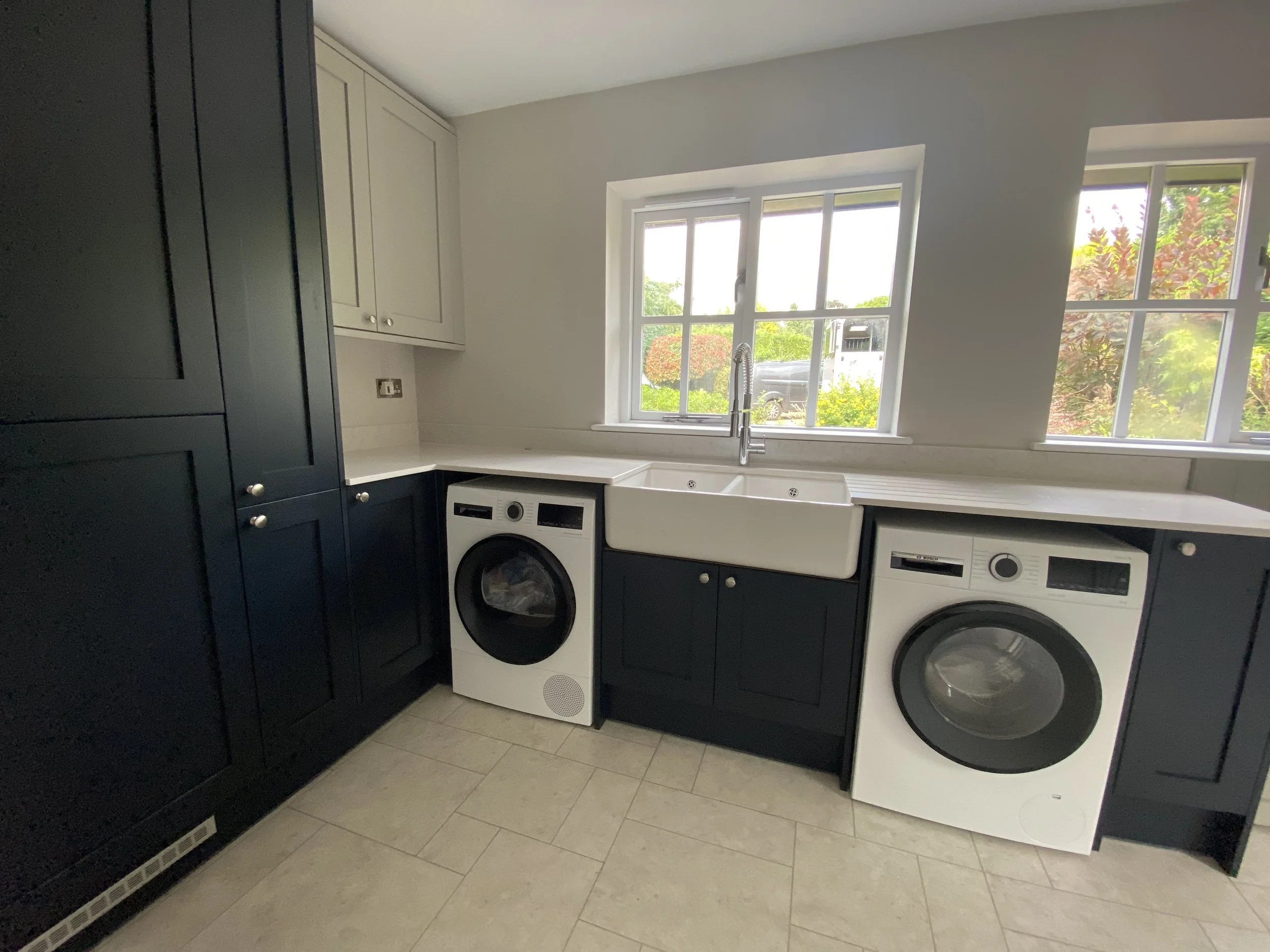Navy blue utility room with Belfast sink