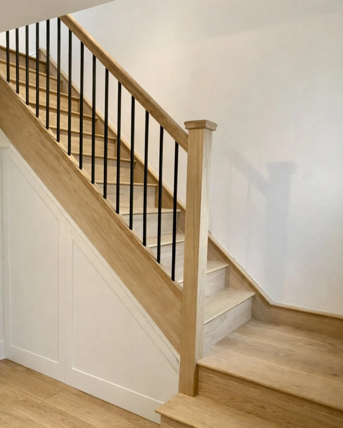 Oak staircase with black metal spindles and understairs storage