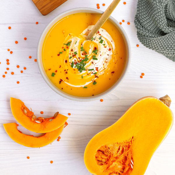 Butternut Kürbis Suppe mit Linsen auf hellem Hintergrund und in heller Schale
