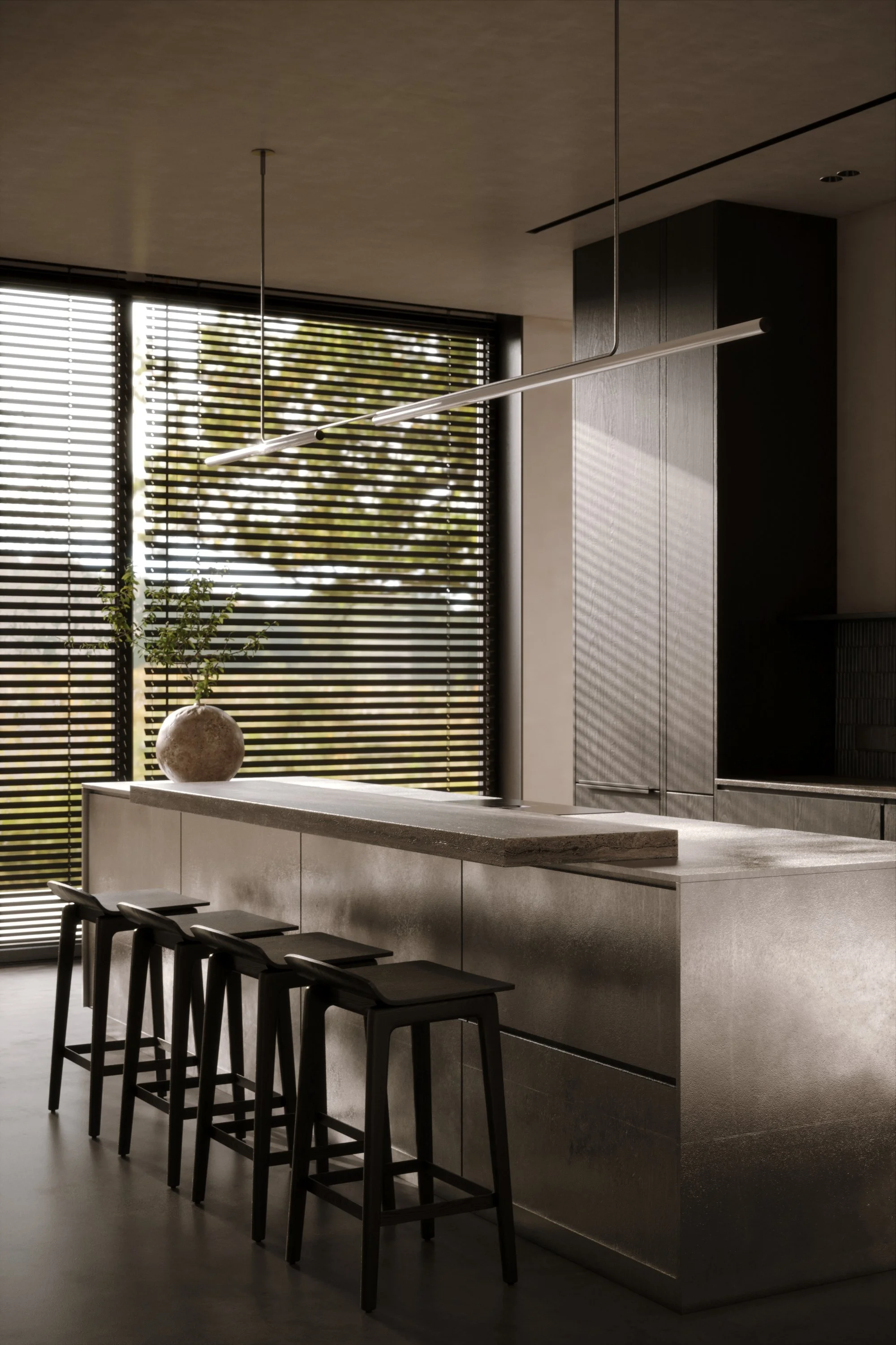 Modern kitchen with a metallic island, black bar stools, and large window with wooden blinds allowing sunlight, and a minimalist vase with greenery on the counter.