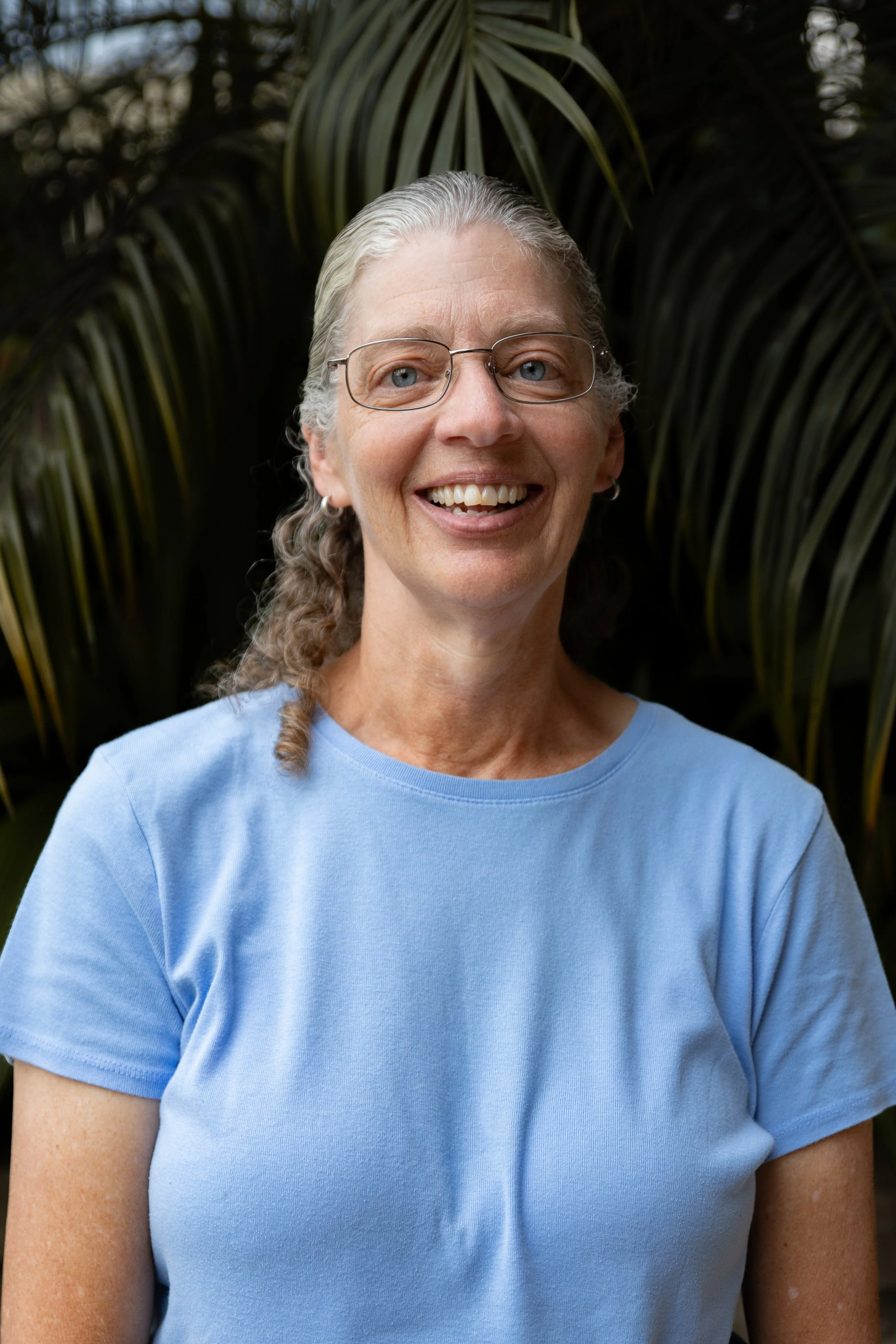 Smiling woman with glasses and a blue shirt