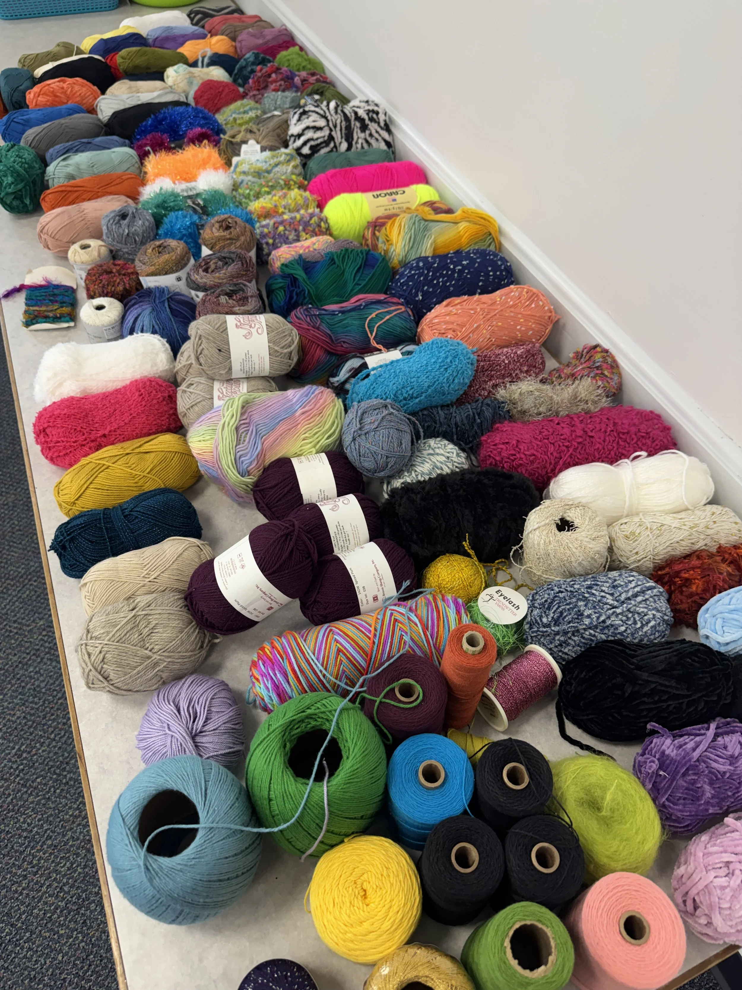 An assortment of yarns brought for a rigid heddle weaving workshop