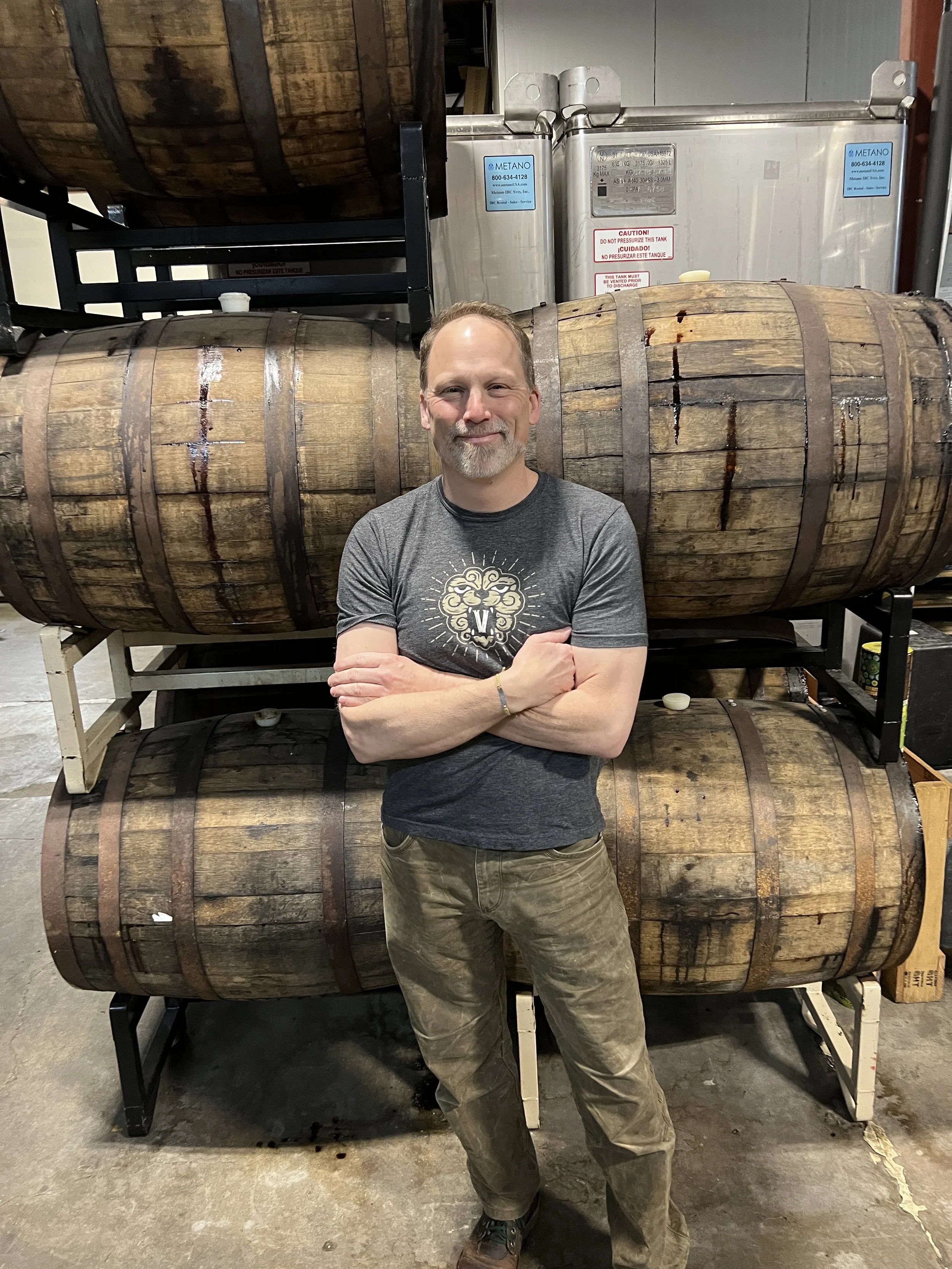 Photo of Charles Porter, the Co-Owner, in front of a foeder