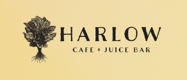 Sign for Harlow Cafe + Juice Bar with a tree logo on a yellow background.