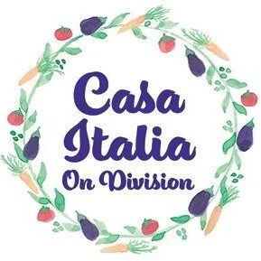 A circular decorative wreath of vegetables and herbs surrounds the text 'Casa Italia On Division' in purple font.