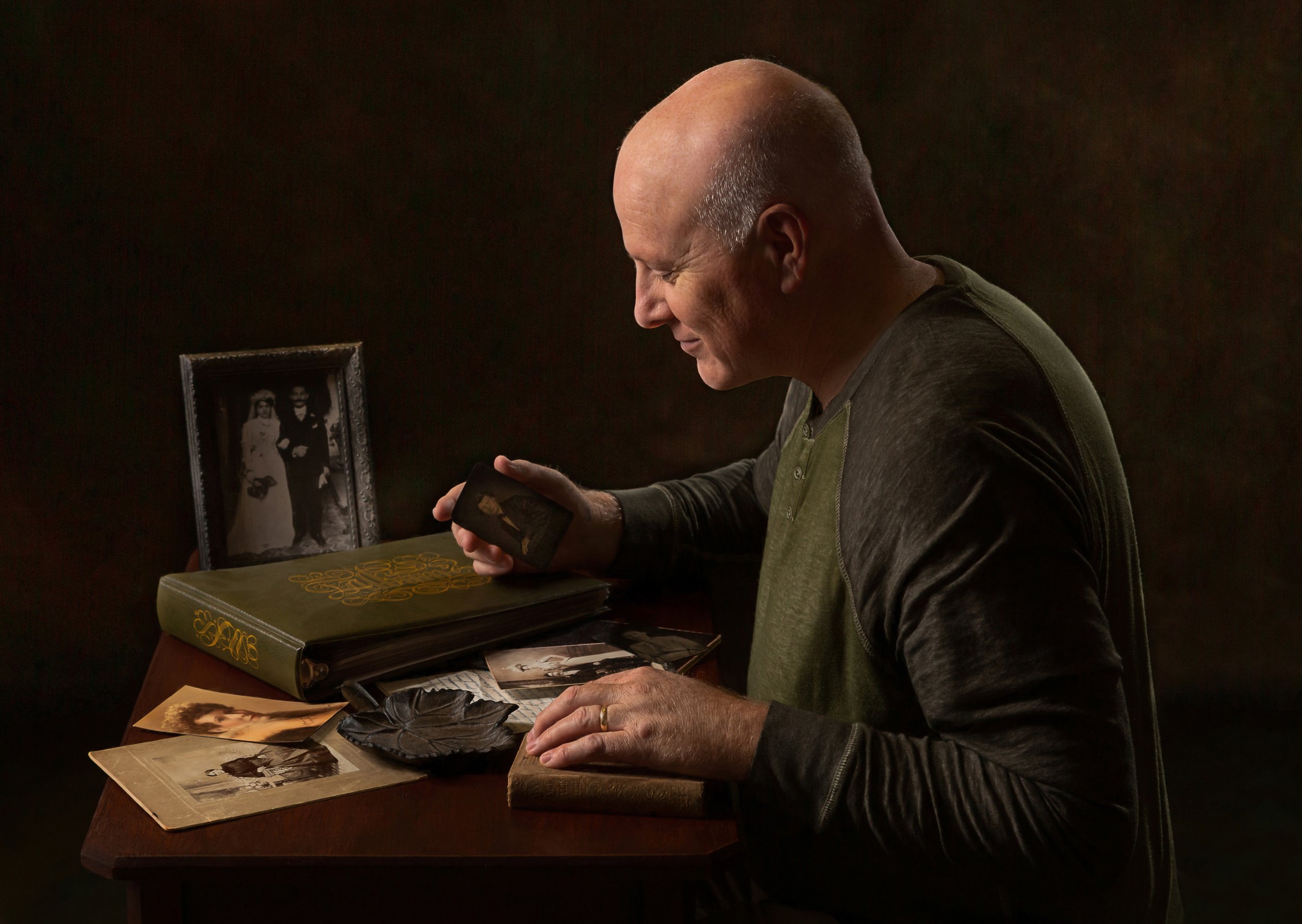 Introspective portrait of a genealogist reviewing photos and records.
