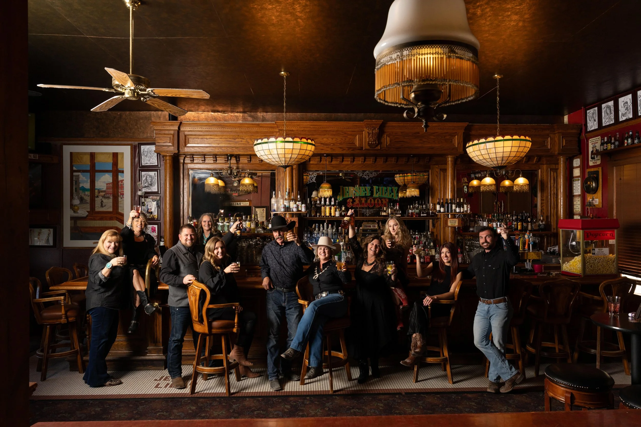 Heirloom portrait of 11 at a rustic bar. 