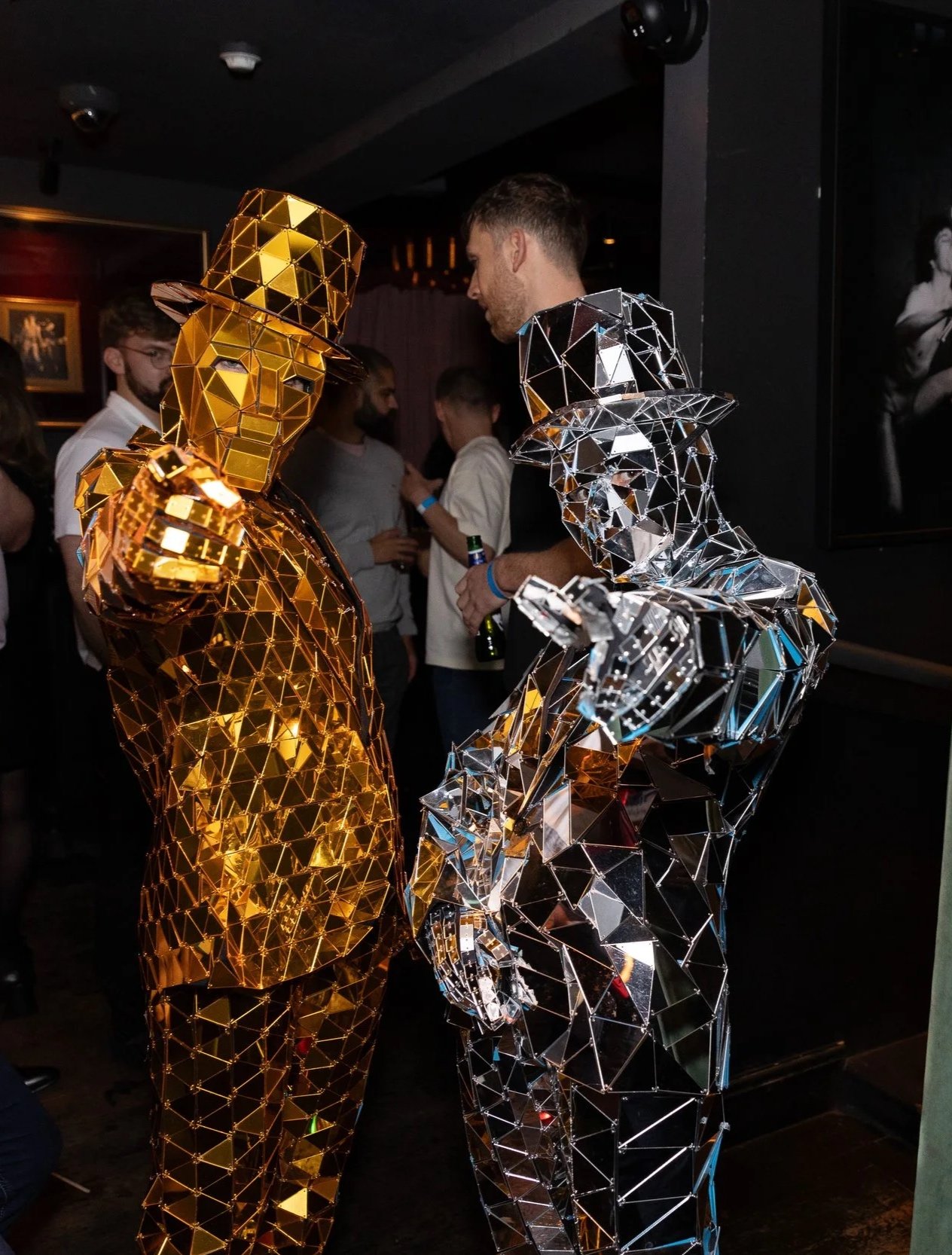 Gold and silver mirror men masquerade dancers at a corporate event Christmas party in Soho London. 