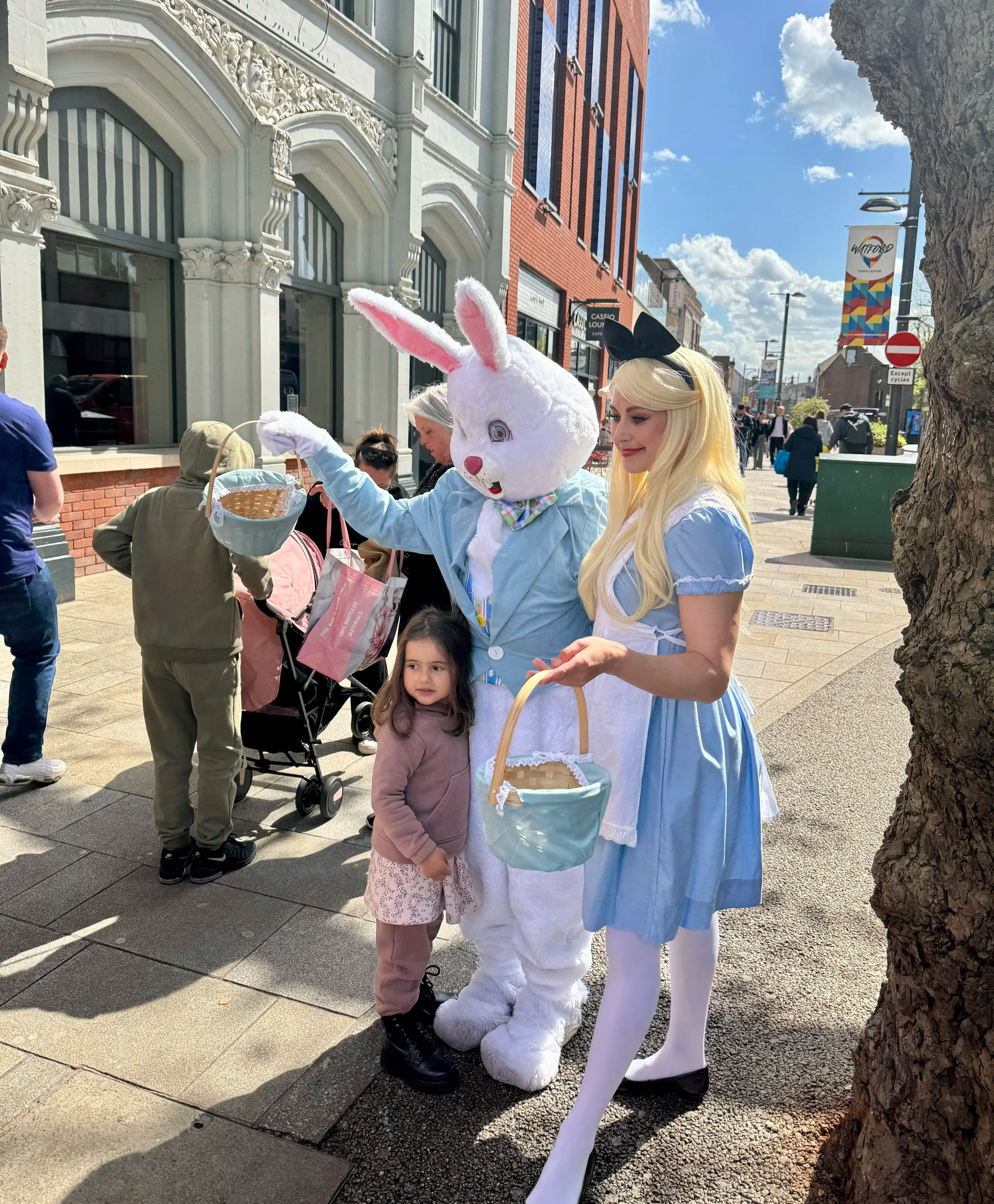 Easter Bunny mascot and Alice in Wonderland with guest at Easter event on Watford High Street