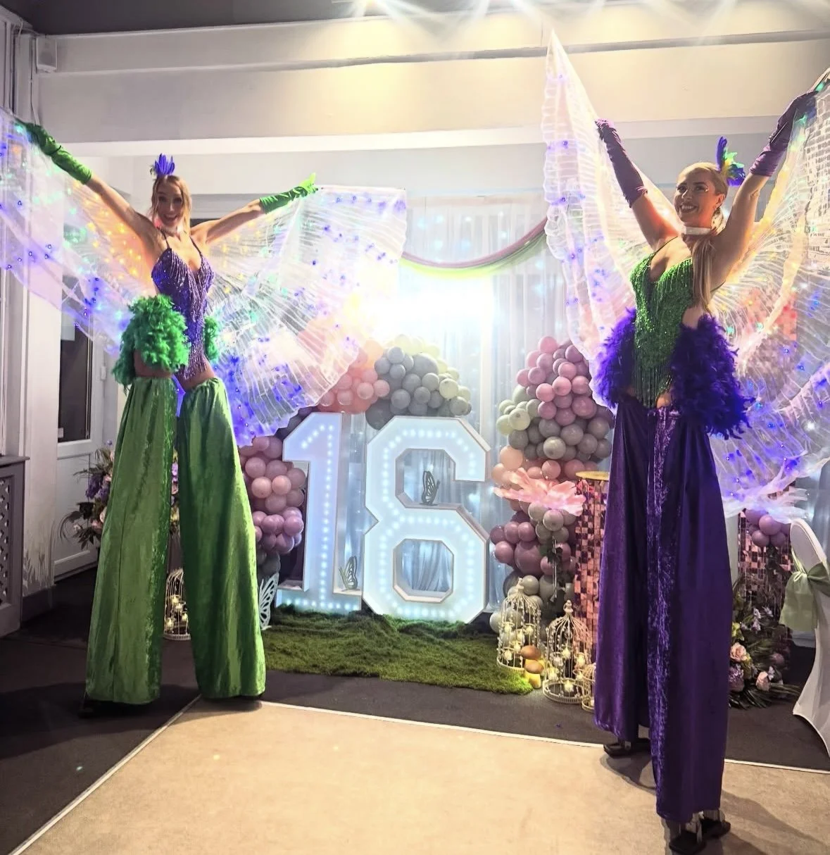princess and the frog themed green and purple showgirl stilt walkers at a 16th birthday party at Edmonton sports club 