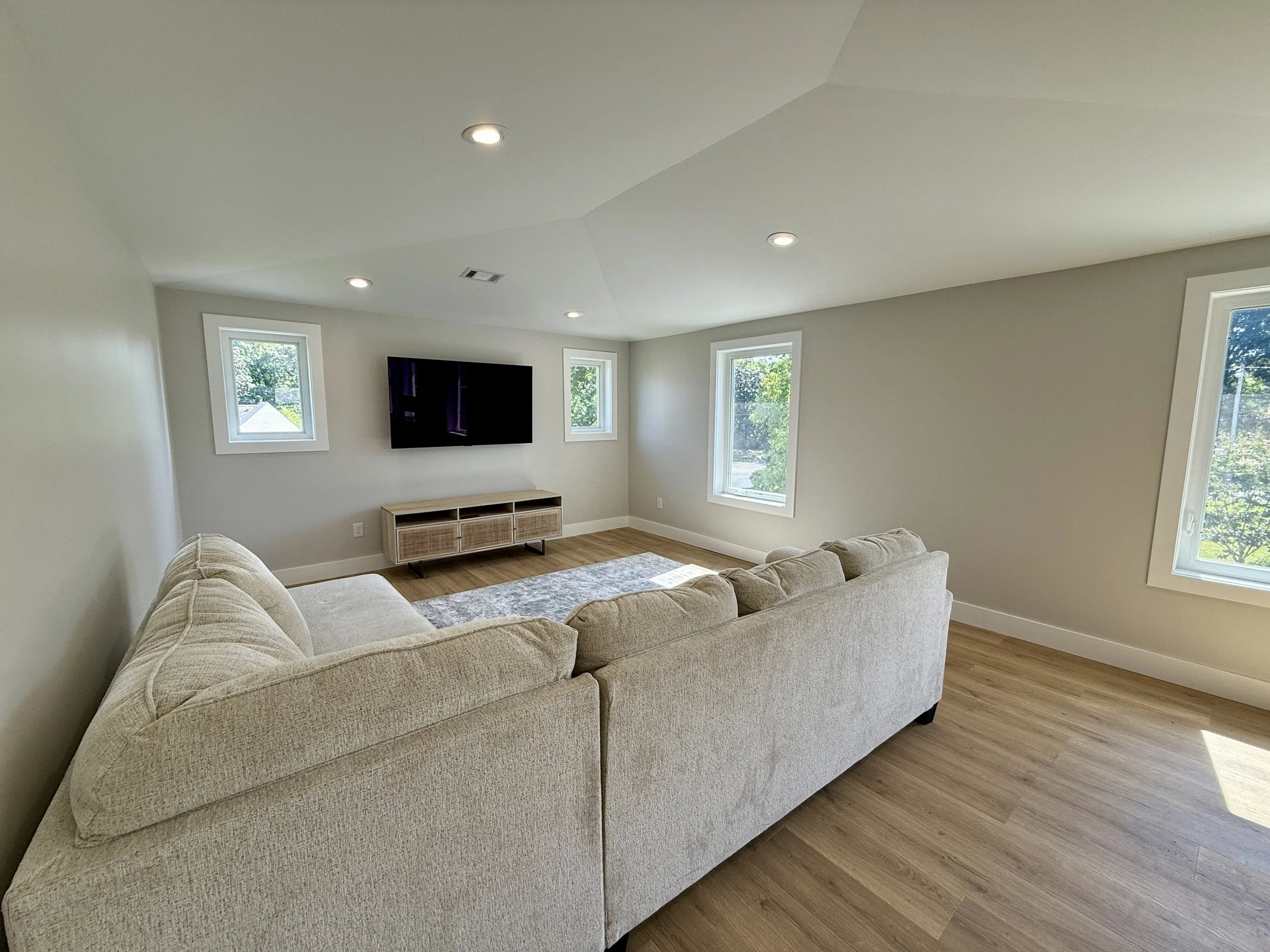 Bright living room with large windows and mounted TV inside a custom-built DADU added to a West Meade home.