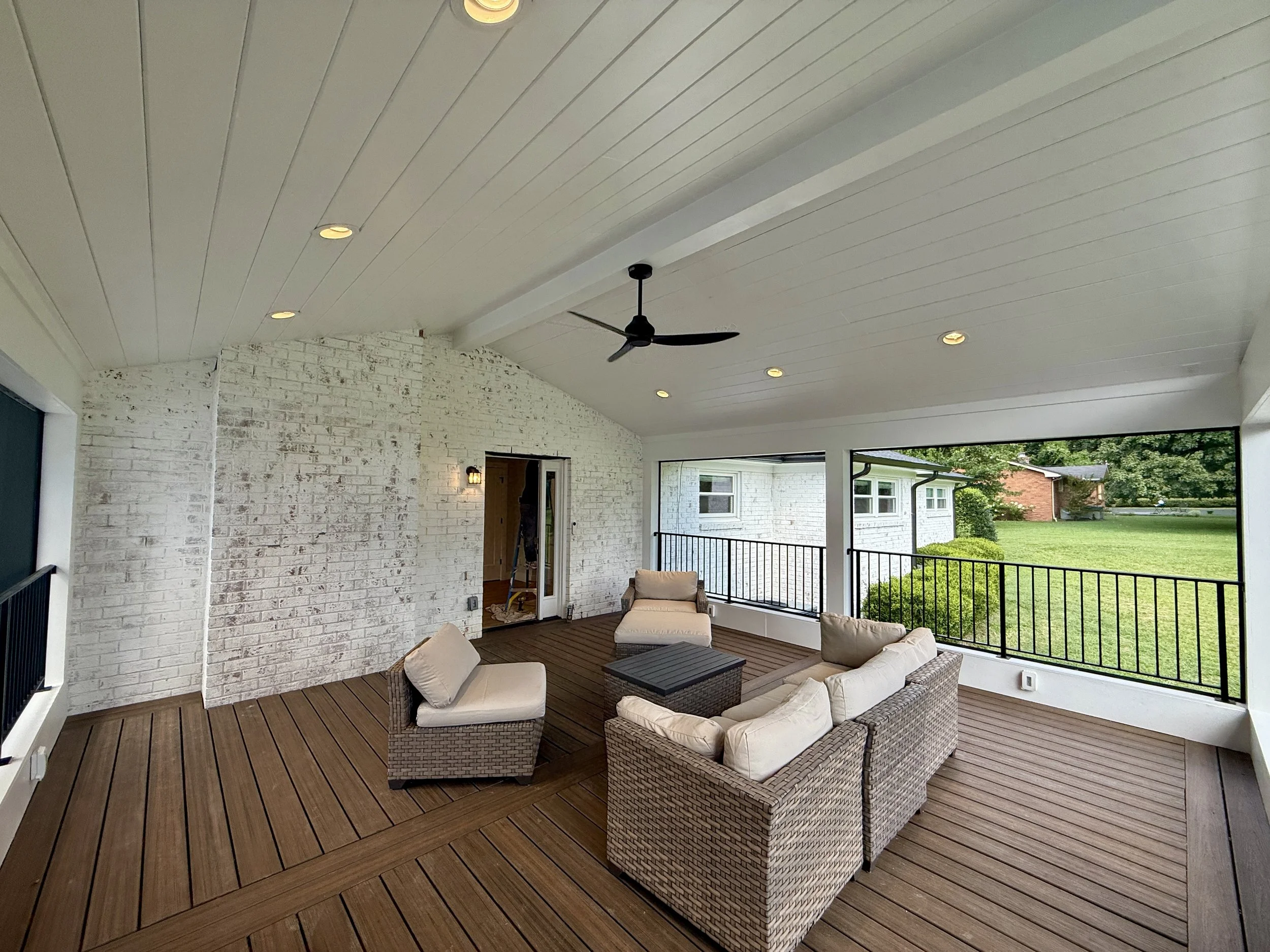 Screened porch with painted brick, tongue-and-groove ceiling, and composite decking added to an existing home in Nashville.