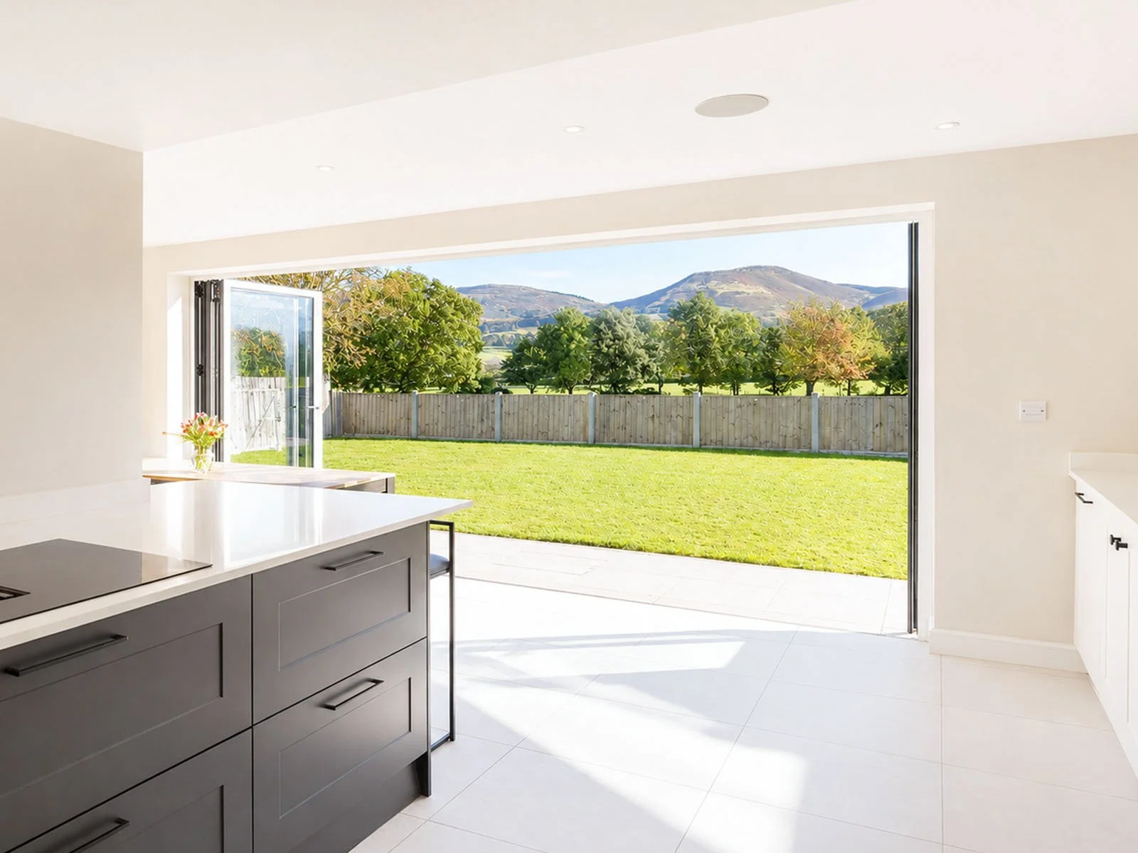 Contemporary house extension in North Wales with large panoramic glazing overlooking the Clwydian Range, featuring an open-plan kitchen, dining and family living space filled with natural light.