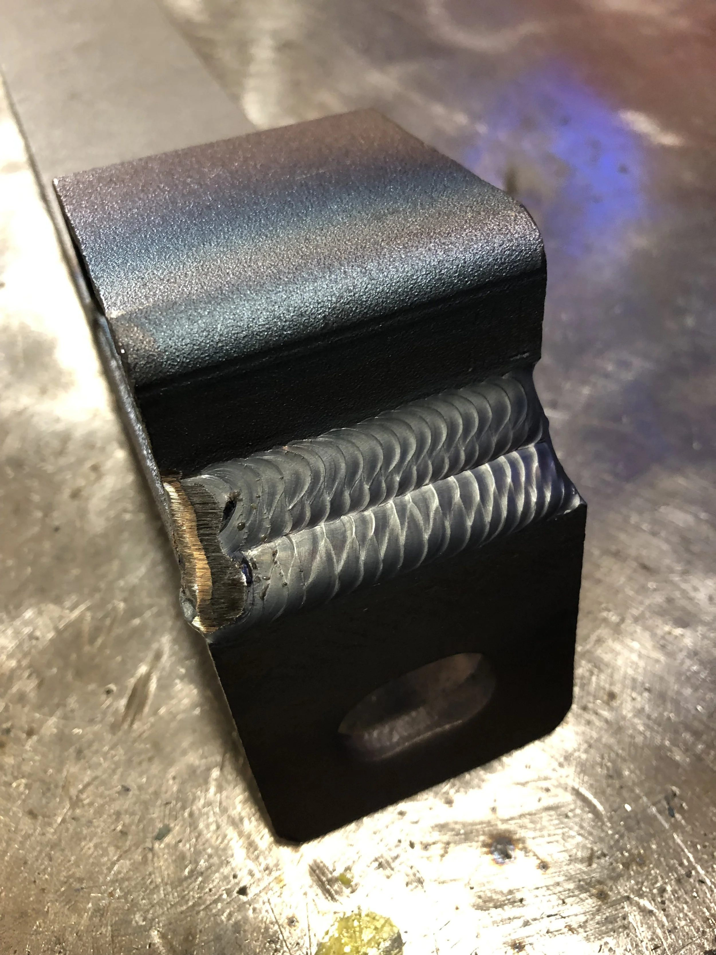 Close-up of a fabricated steel component with finished welds.