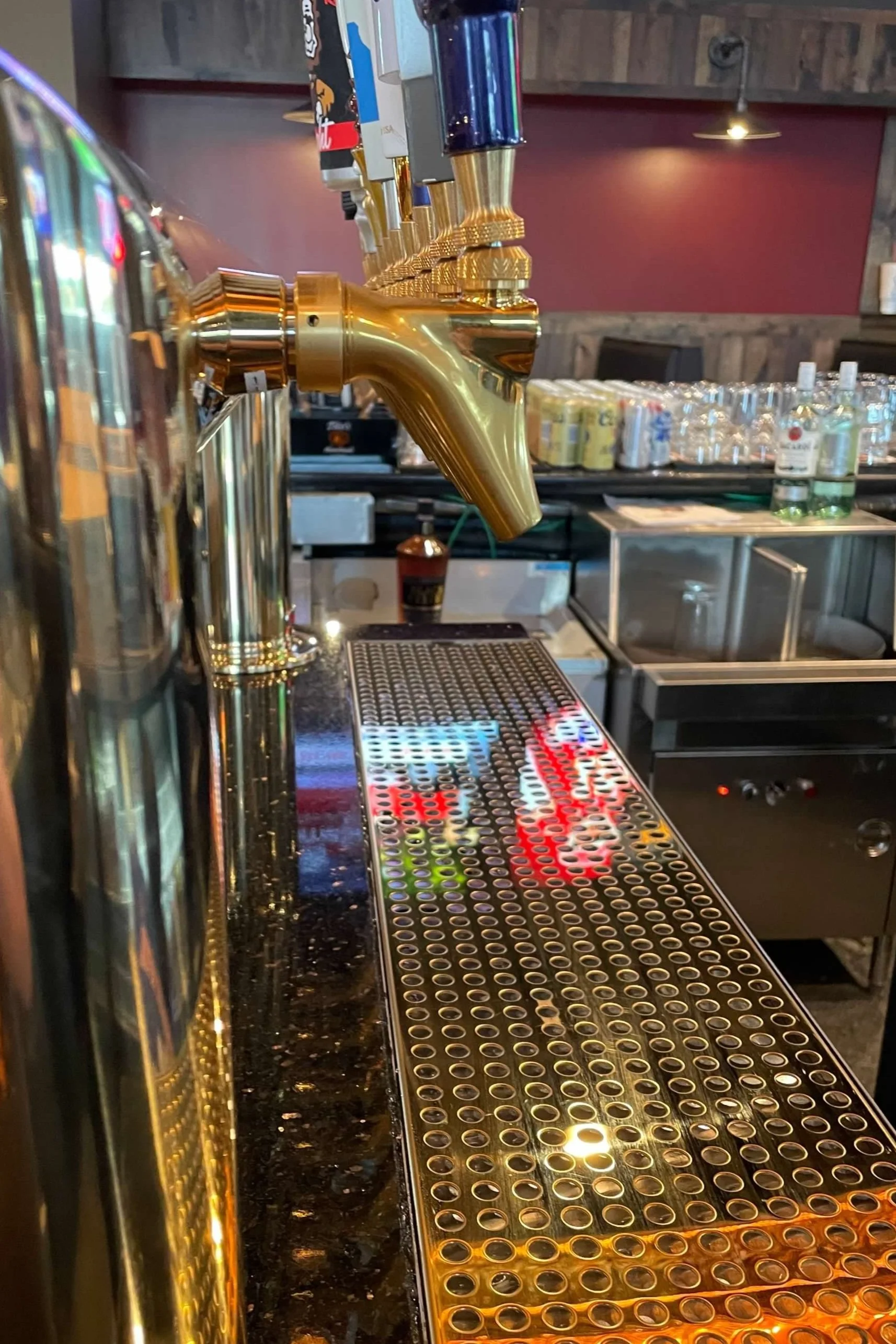 Close-up of beer taps and a drip tray in a bar