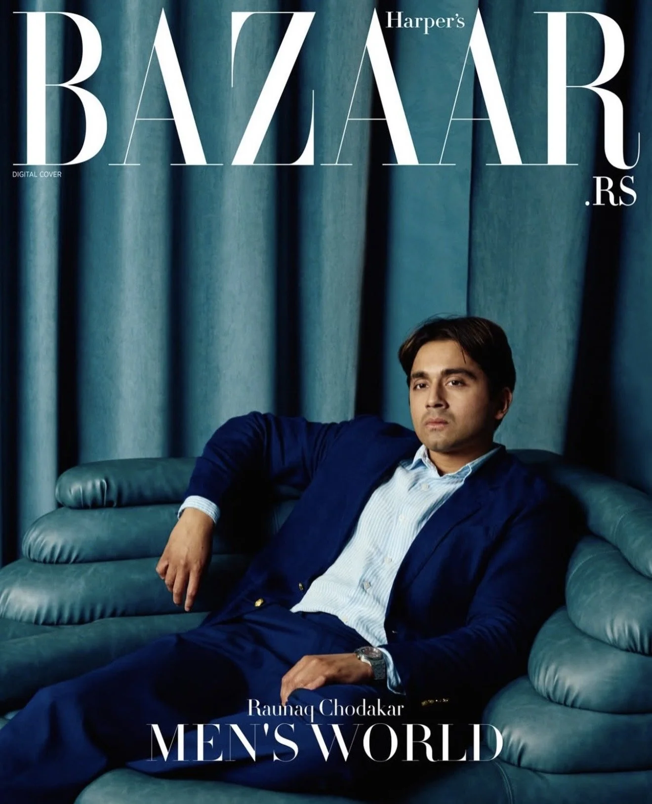Cover of Harper's Bazaar magazine featuring a man in a blue suit sitting on a teal leather couch with teal curtains in the background.