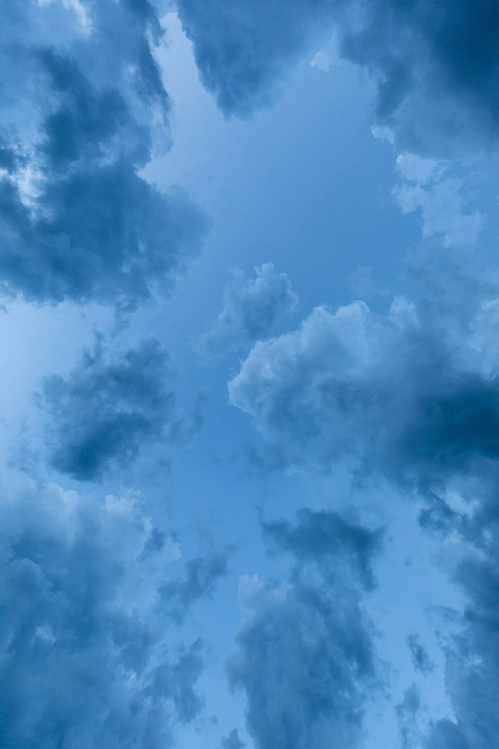 Cloudy sky with various shades of blue and dark clouds.
