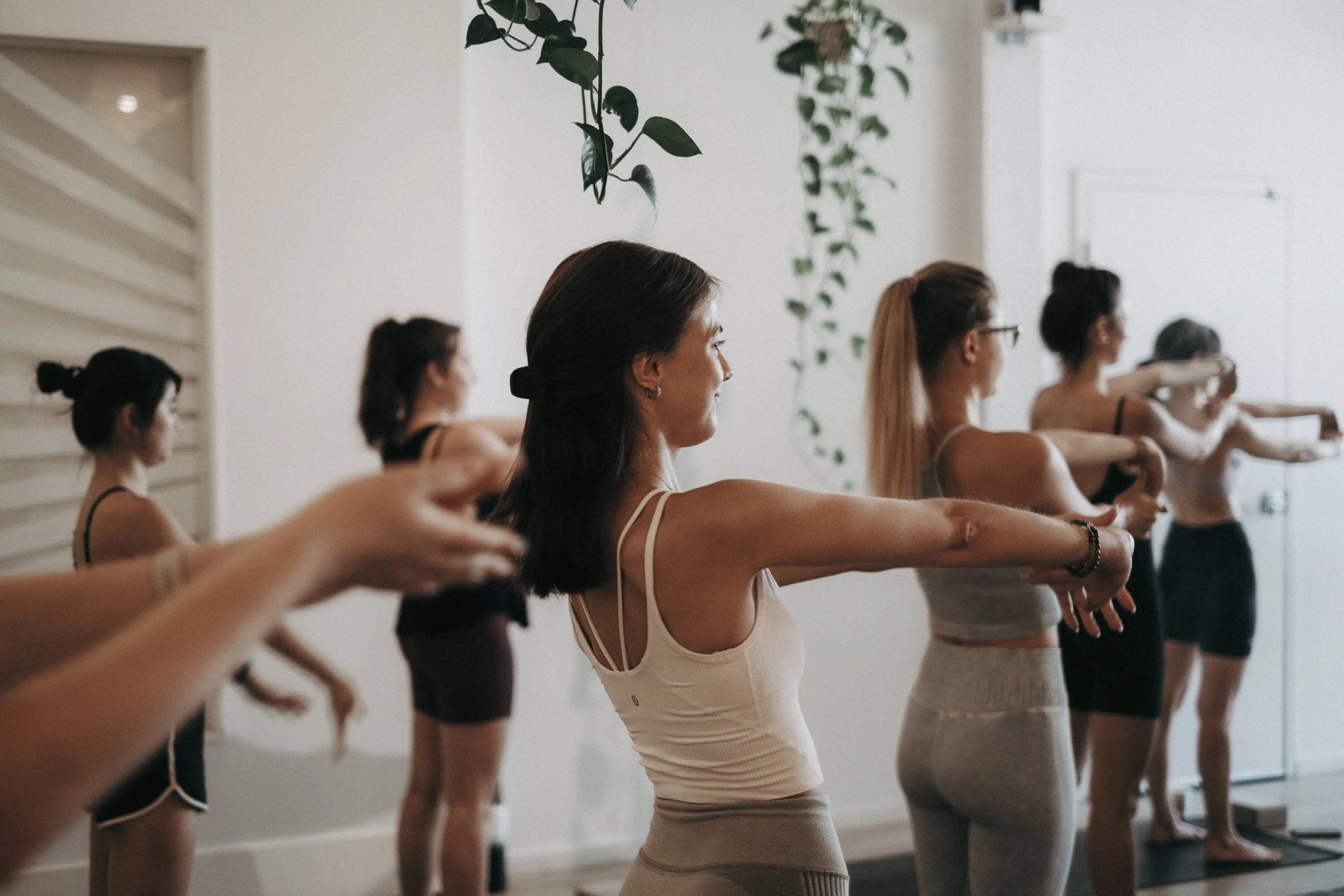 women in a stretching class doing a wrist stretch