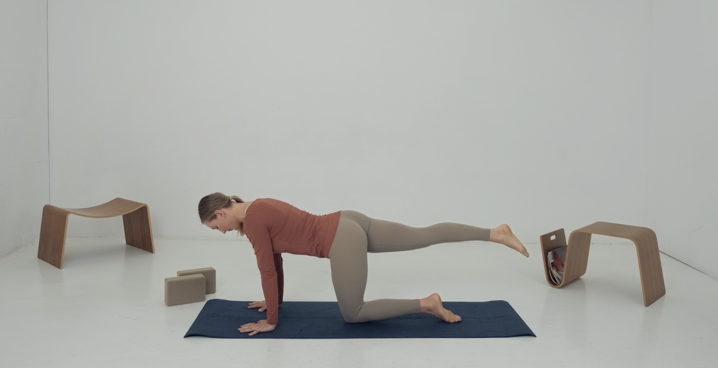 instructor doing table top strength exercise lifting one leg