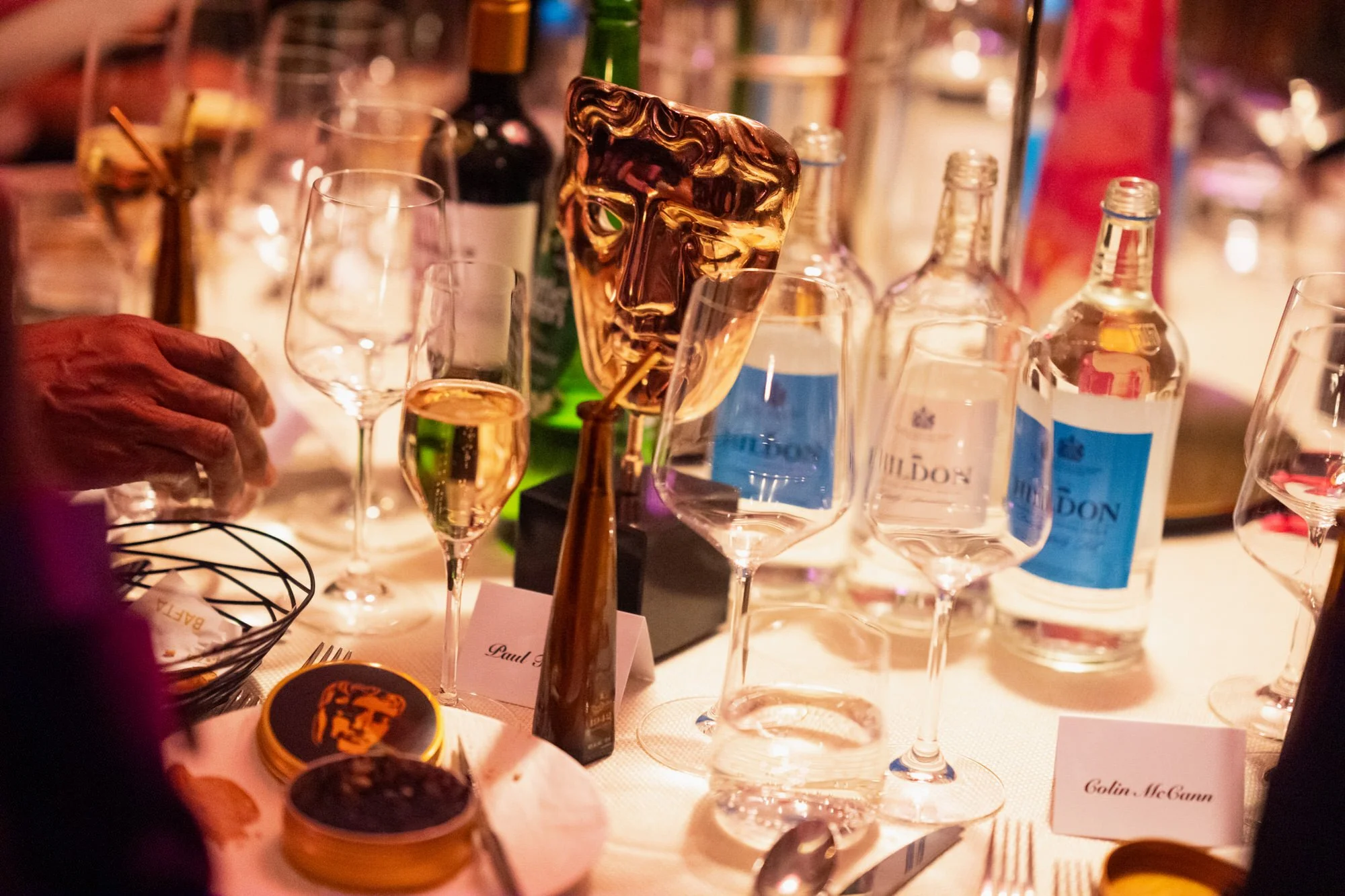 A BAFTA trophy among champagne glasses on a table at the after-party drinks reception.