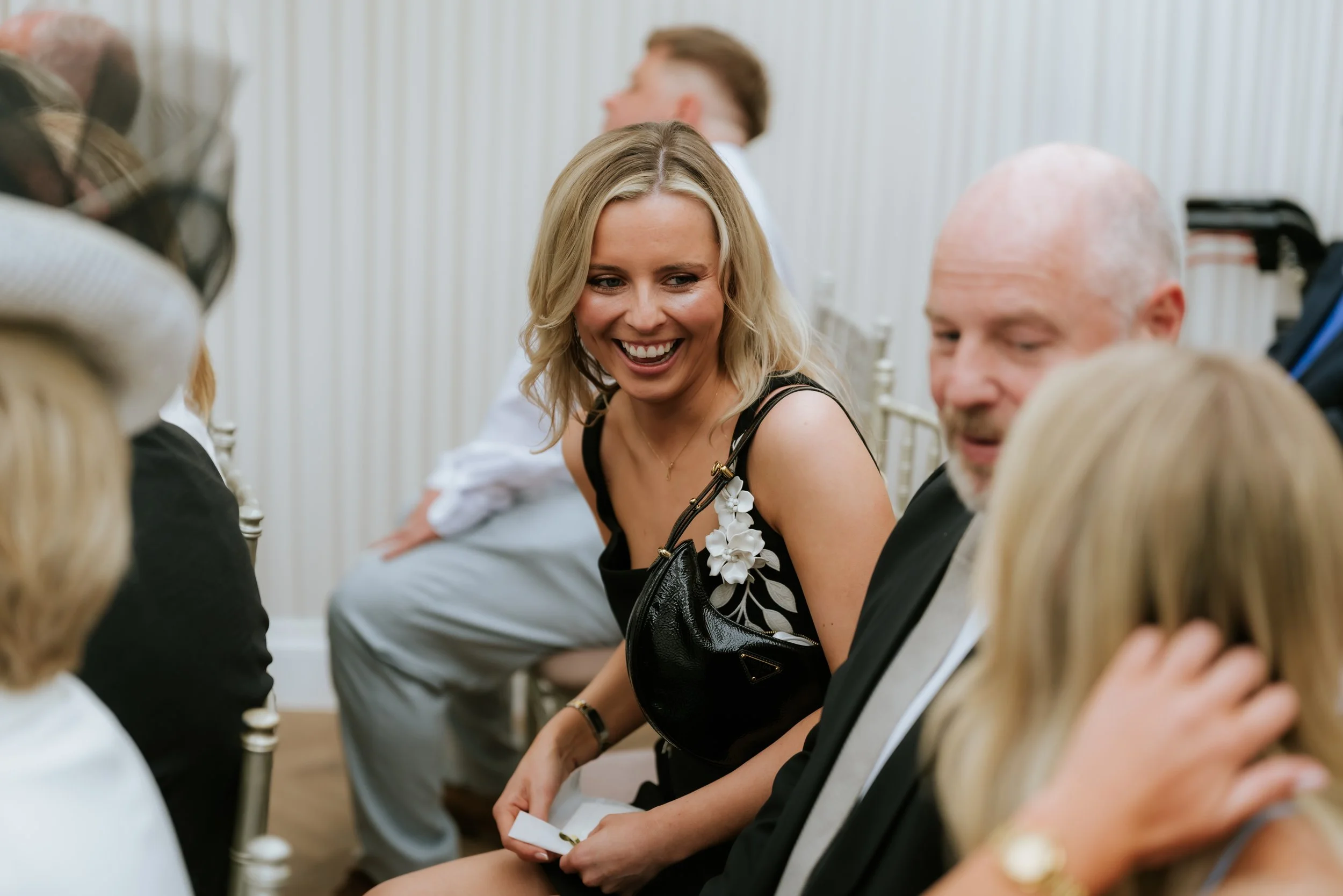 Wedding guests smiling together before the Cornhill Castle ceremony.