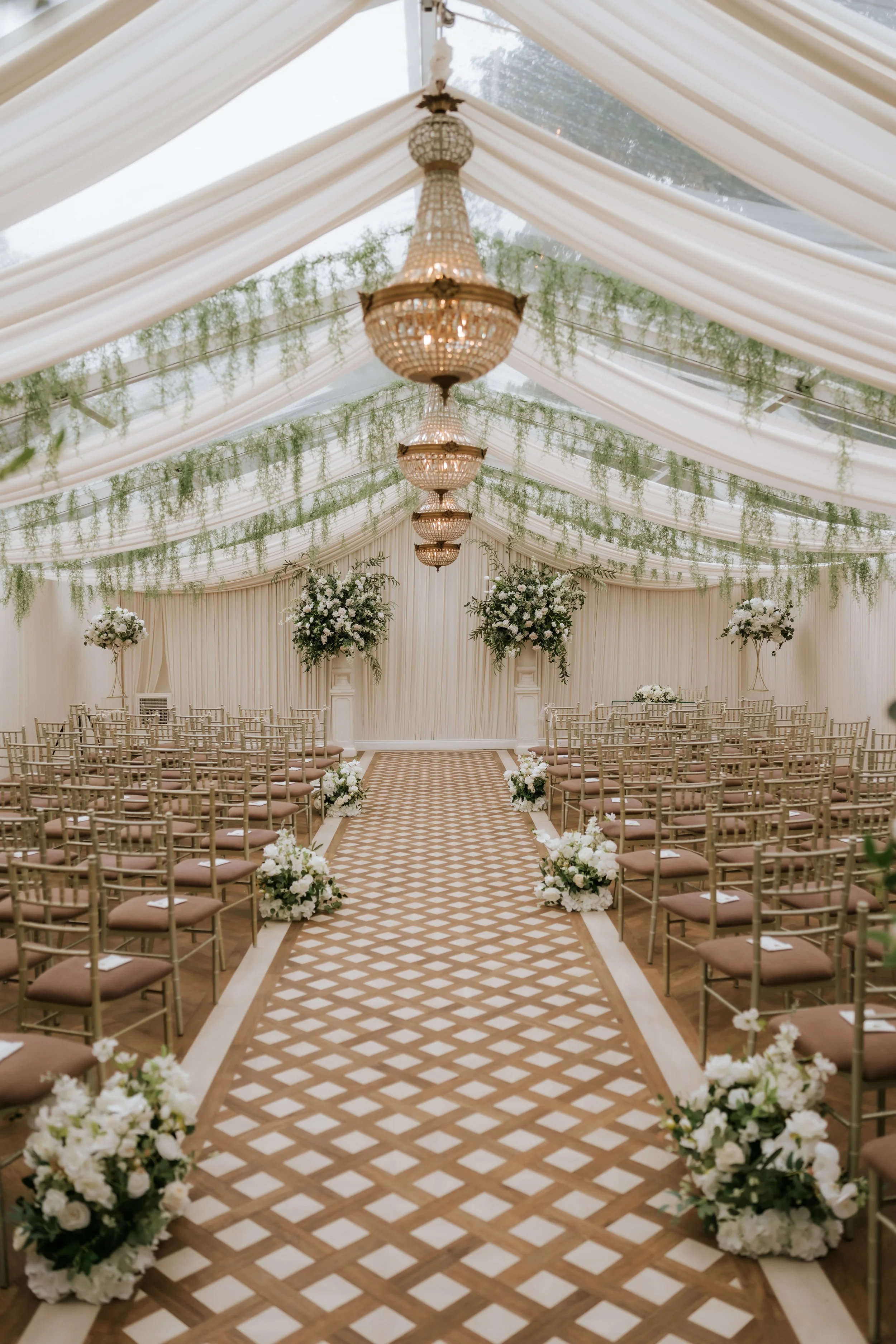 Cornhill Castle’s refurbished wedding pavilion with chandeliers, drapery, greenery and a patterned aisle.