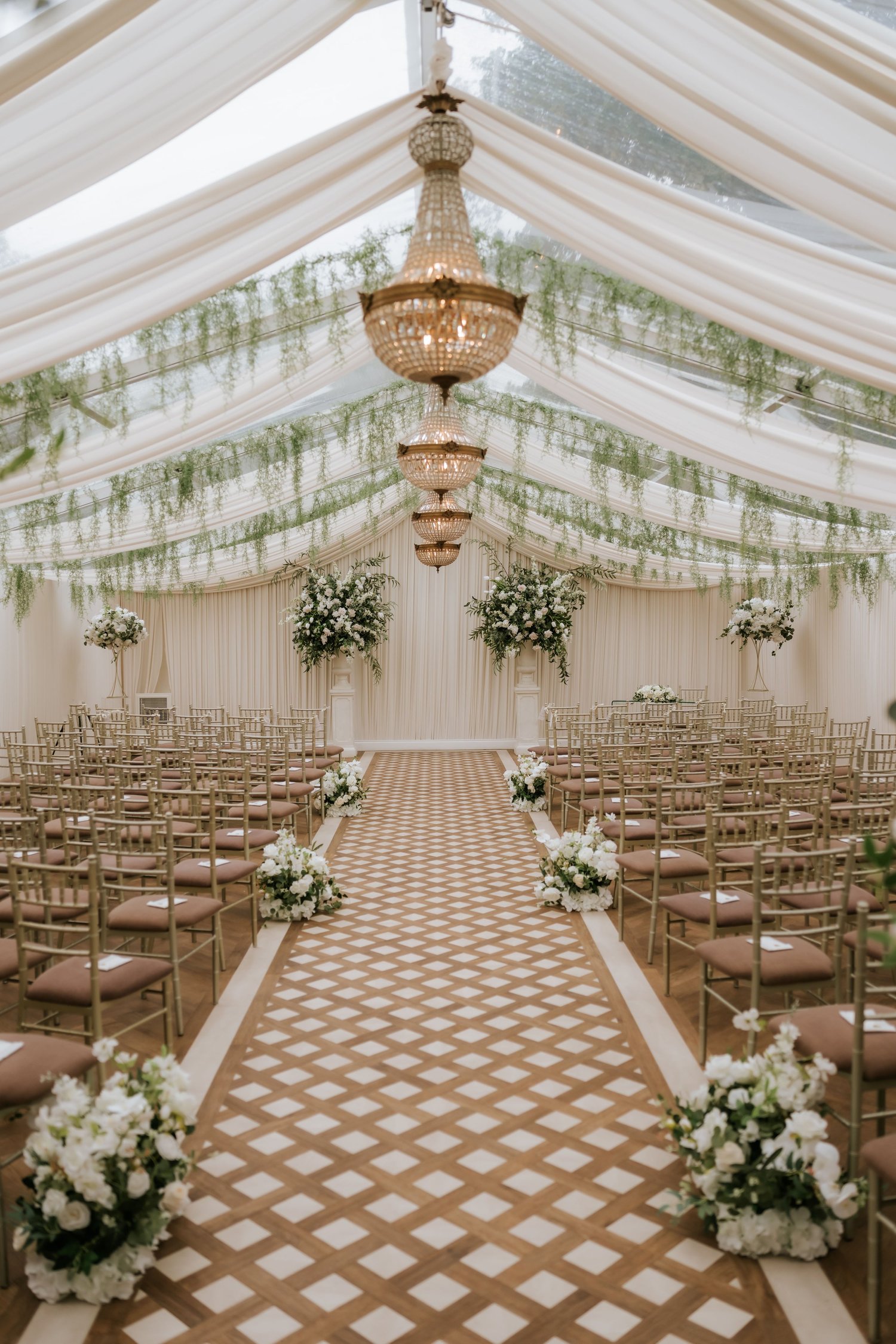 Cornhill Castle’s refurbished wedding pavilion with chandeliers, drapery, greenery and a patterned aisle.