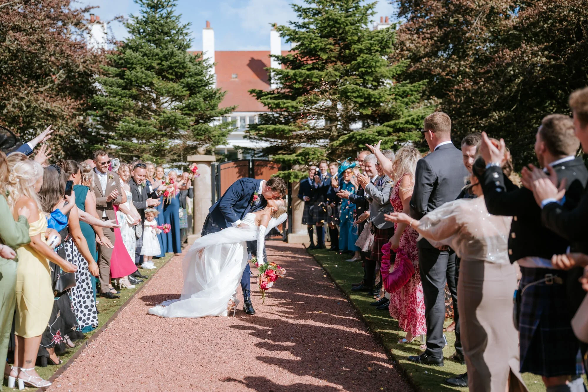 Fiona and Connor kissing beneath a shower of confetti.