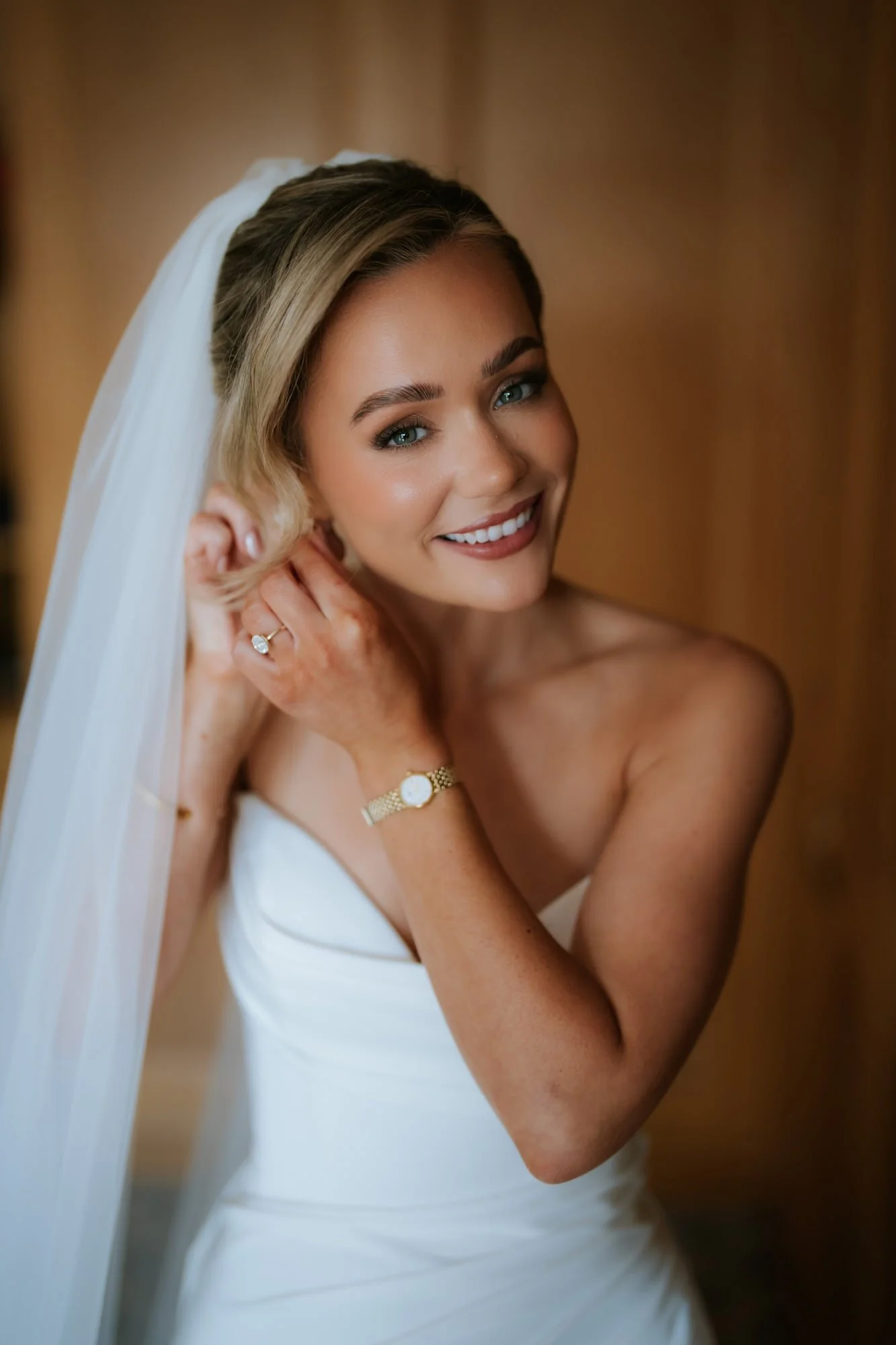 Fiona putting on her earrings before the wedding at Lochgreen.