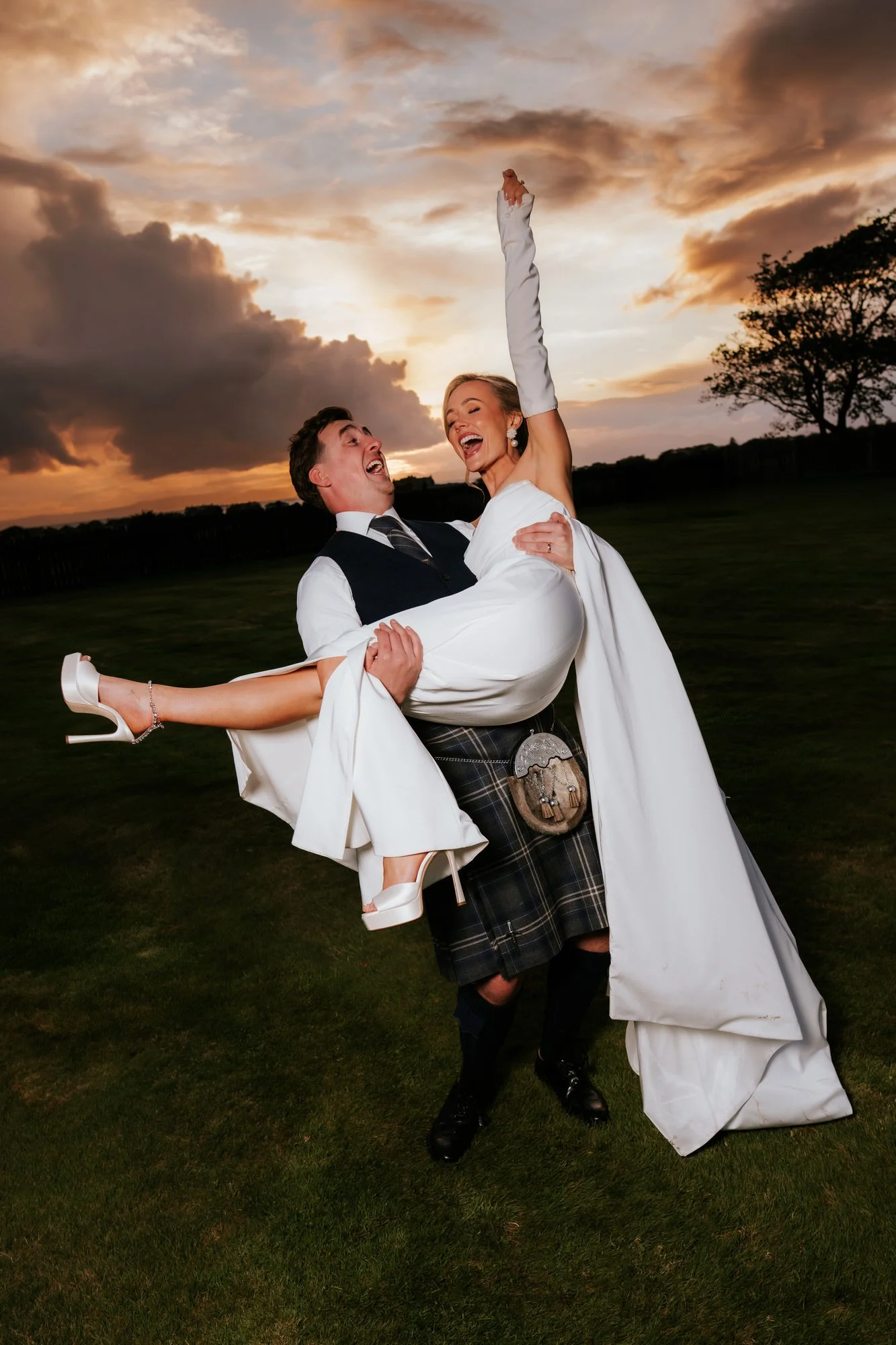 Connor lifting Fiona as she laughs during their sunset portraits.