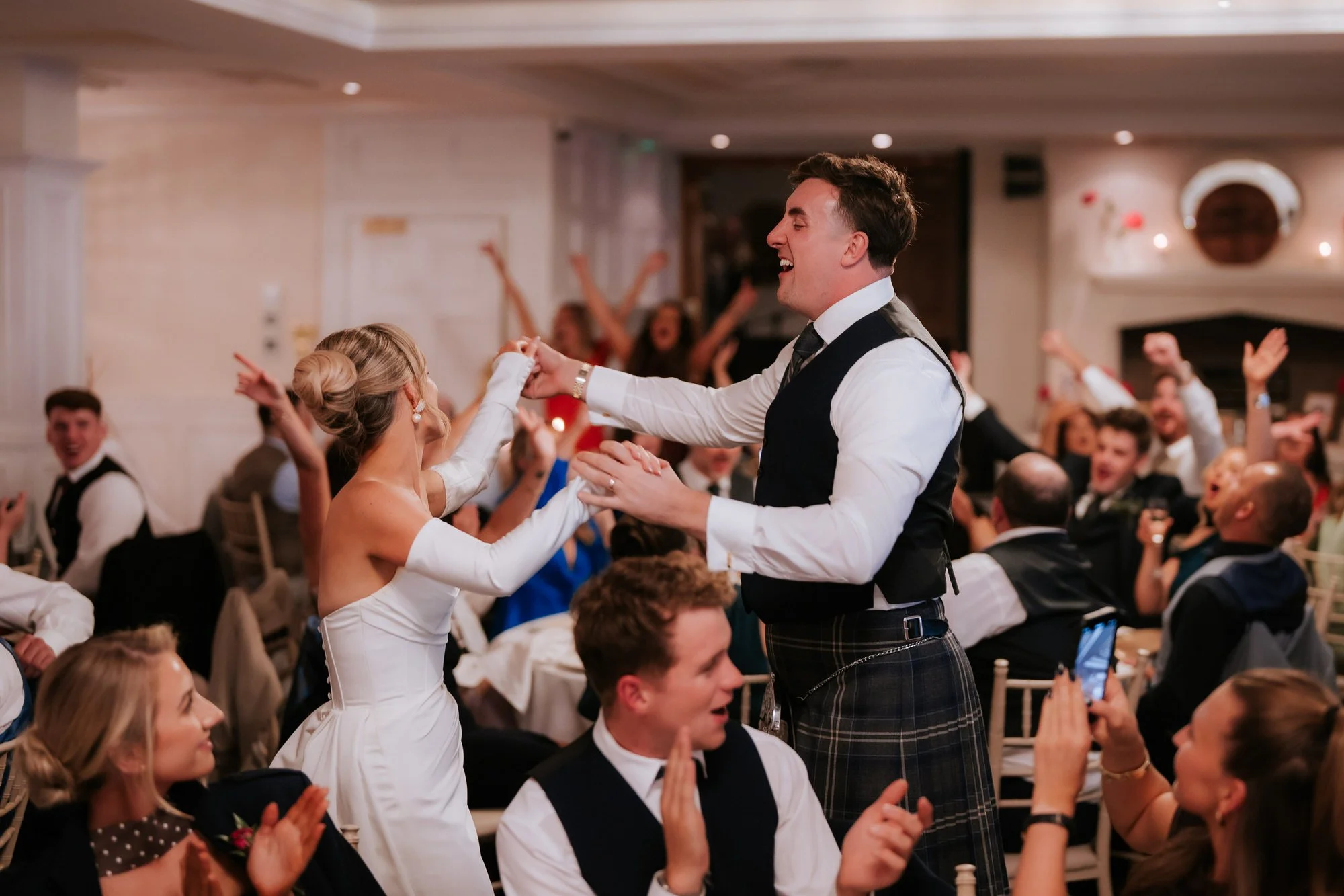 Fiona and Connor dancing among their cheering wedding guests.