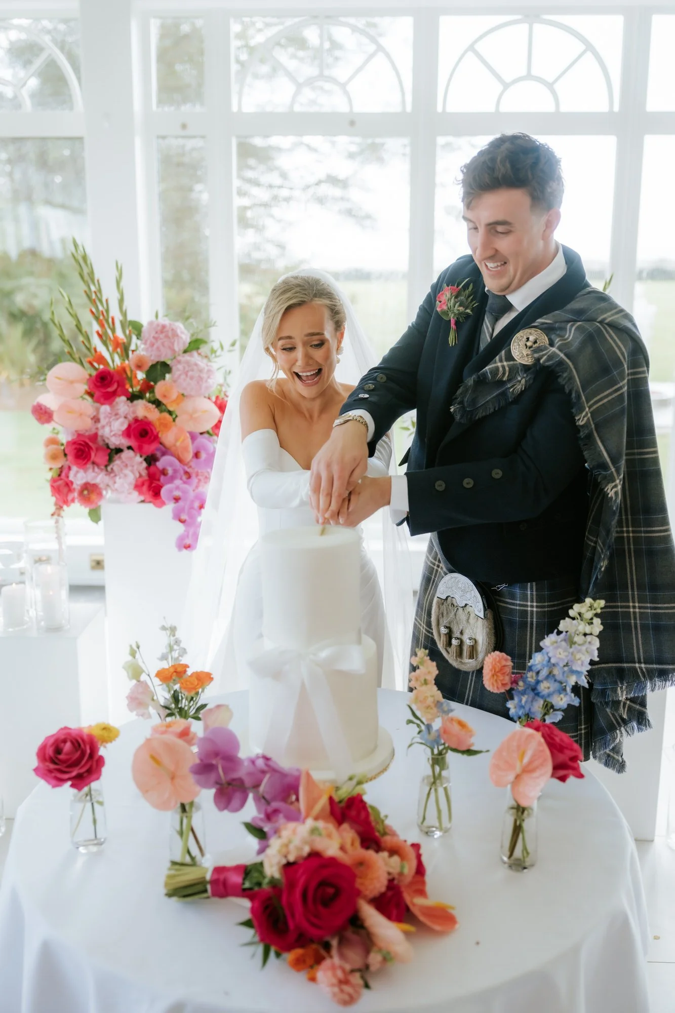 Fiona and Connor cutting their wedding cake.