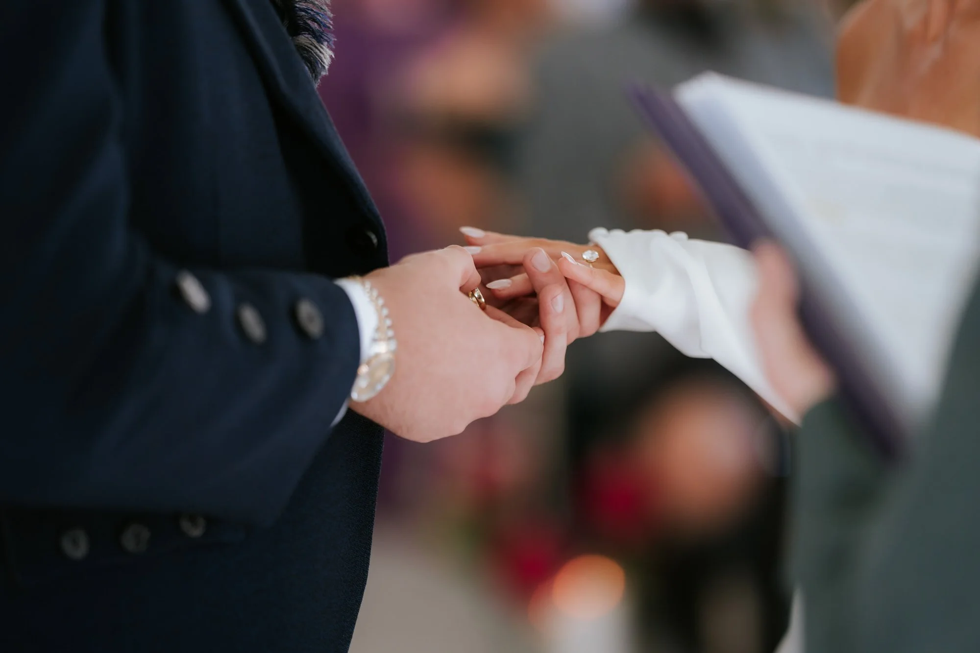 A close view of Fiona and Connor exchanging wedding rings.