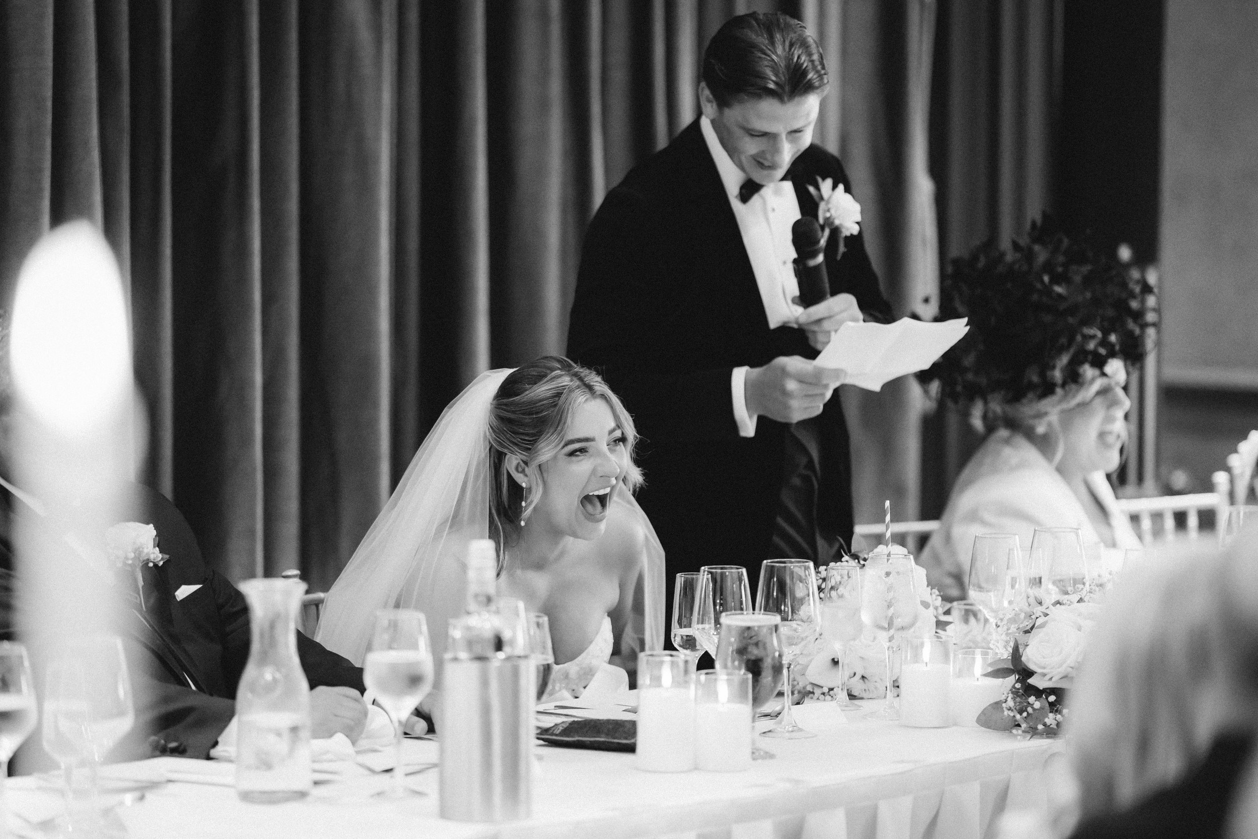 Emma laughing while Frazer reads his wedding speech.