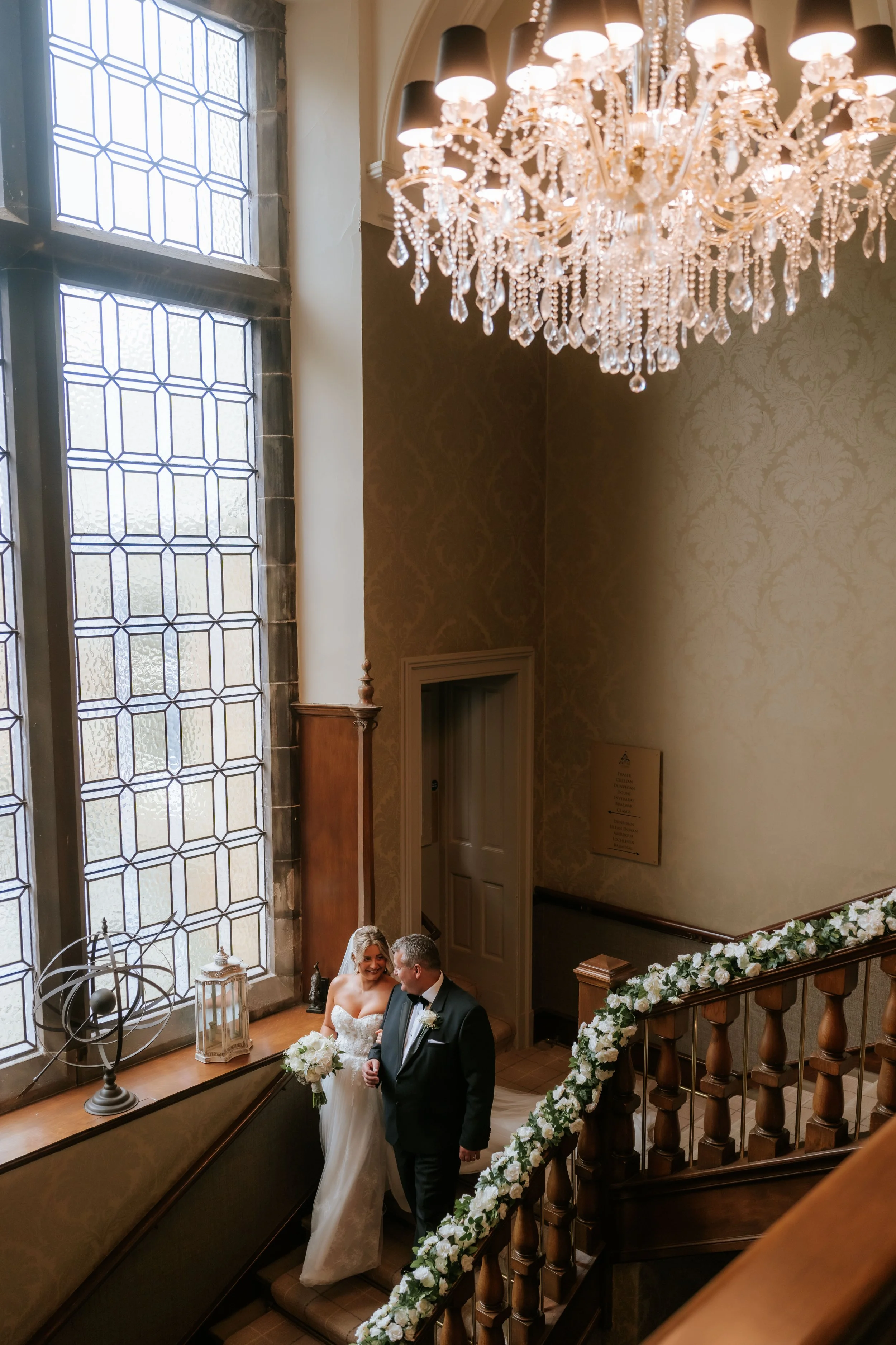 Emma on Cornhill Castle’s staircase beneath a chandelier.