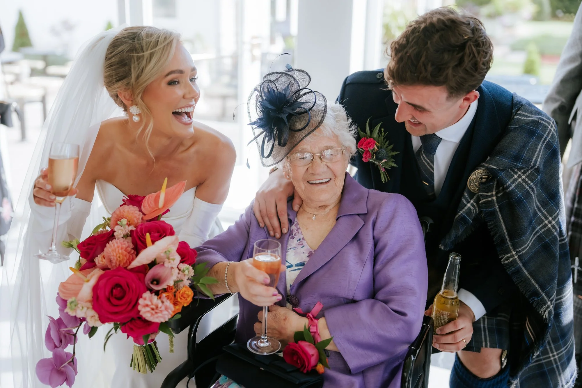 Fiona and Connor sharing a joyful moment with a wedding guest.