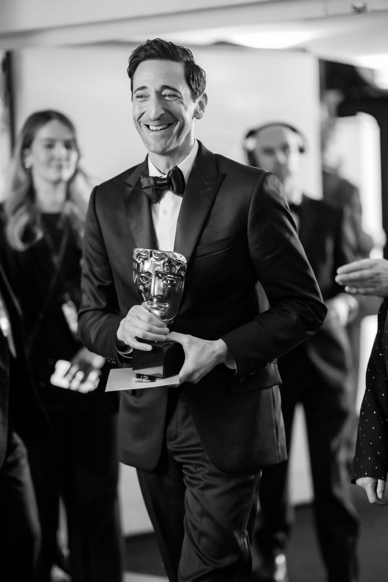 Adrien Brody backstage with his trophy moments after winning at the 2025 BAFTA Film Awards.