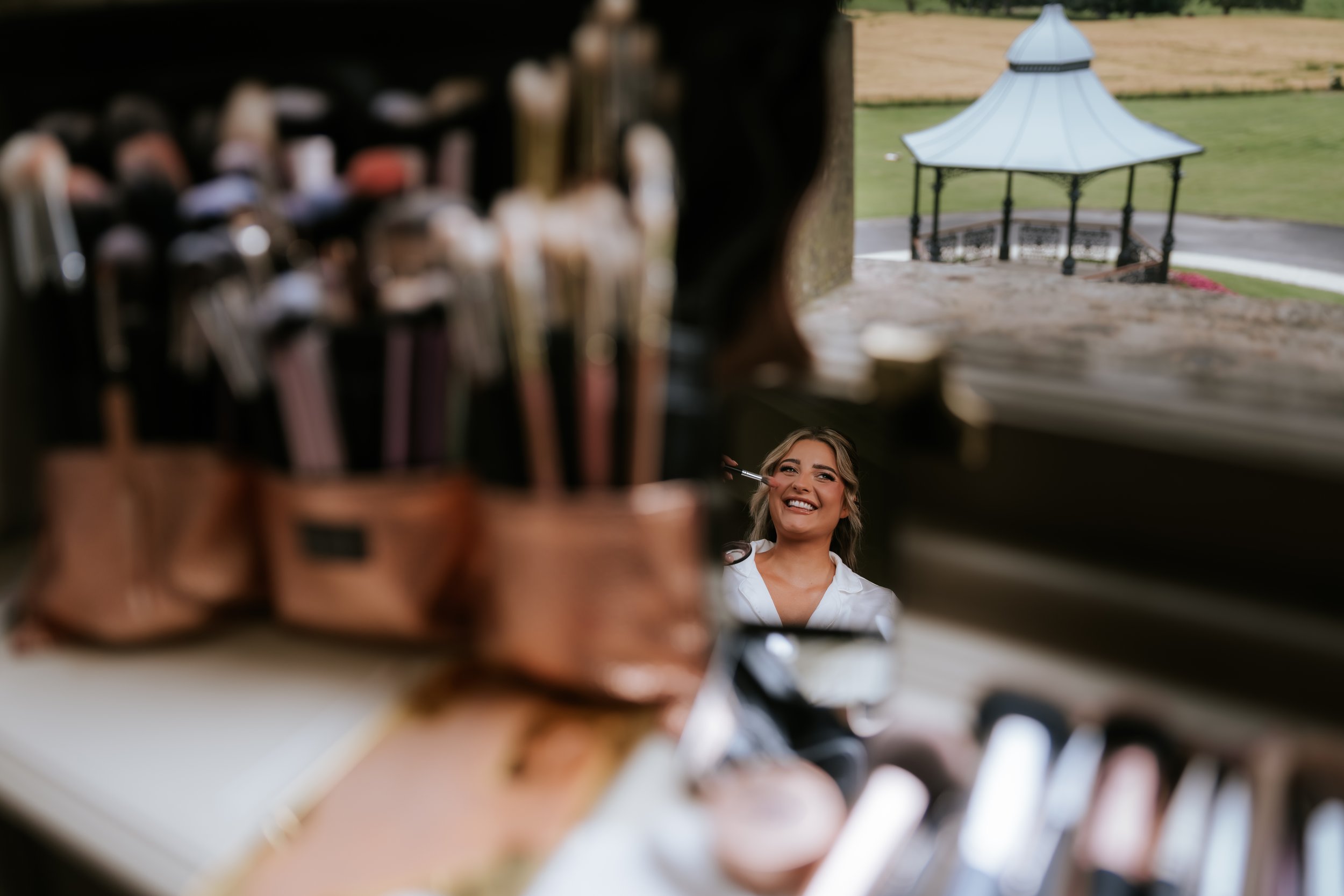 A wedding guest reflected in a mirror, with Cornhill Castle’s bandstand visible through the window.