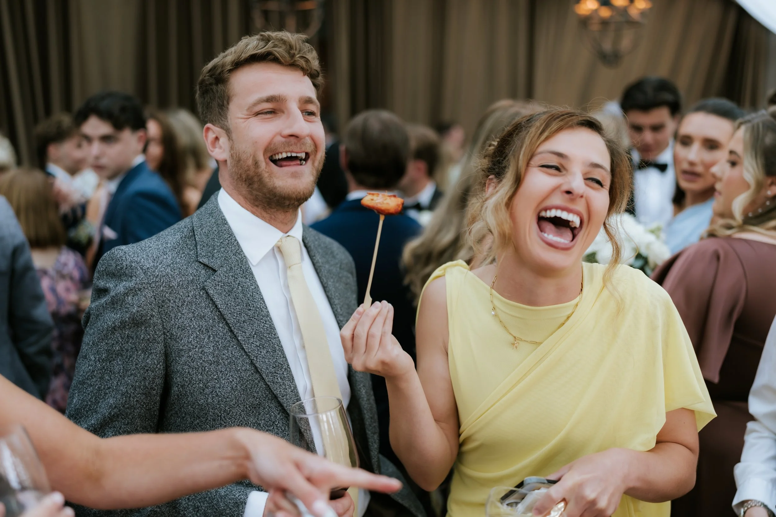 Two guests laughing together at Emma and Frazer’s wedding reception.