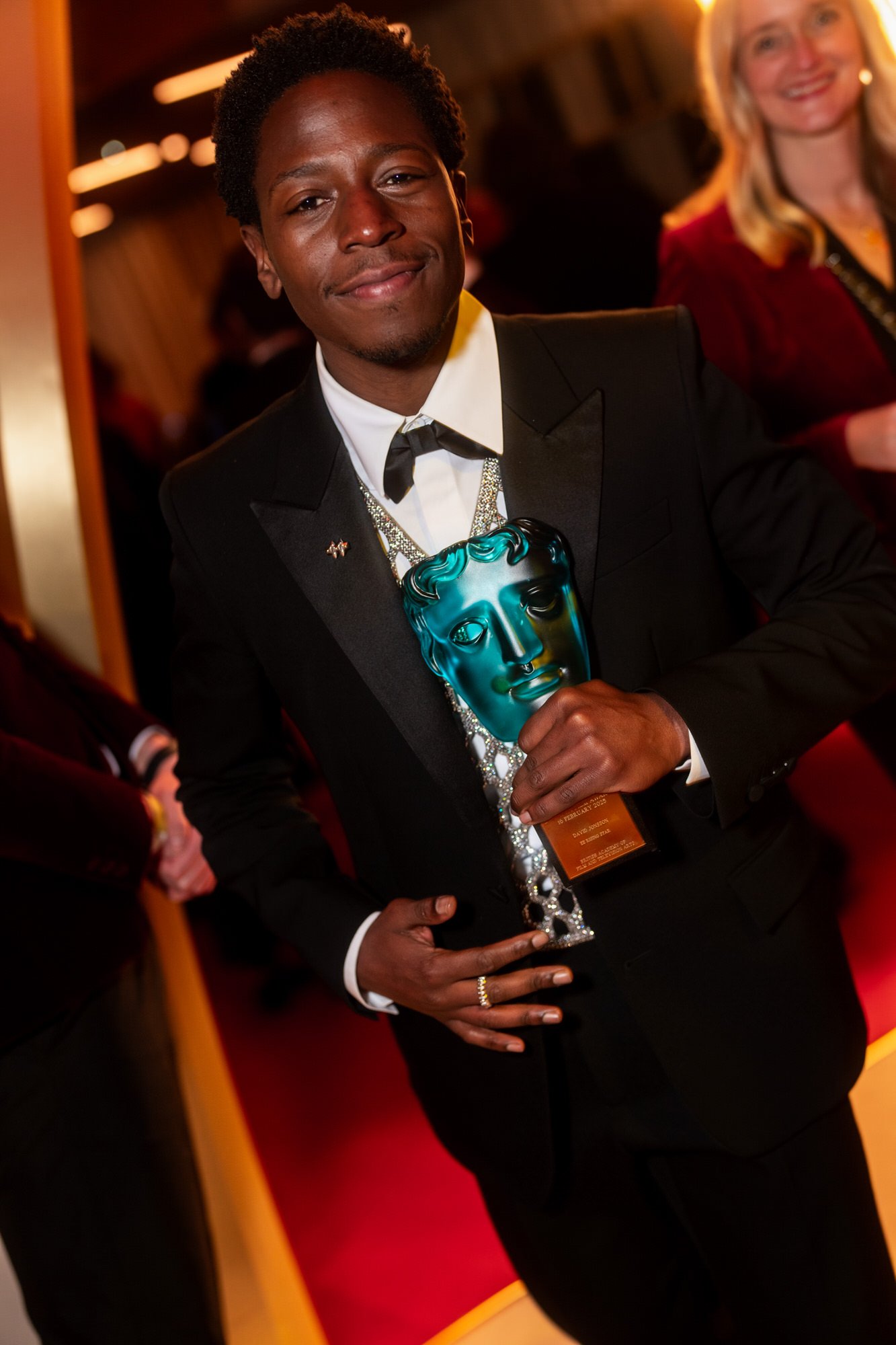 David Jonsson holding his blue EE Rising Star Award at the 2025 BAFTA Film Awards.