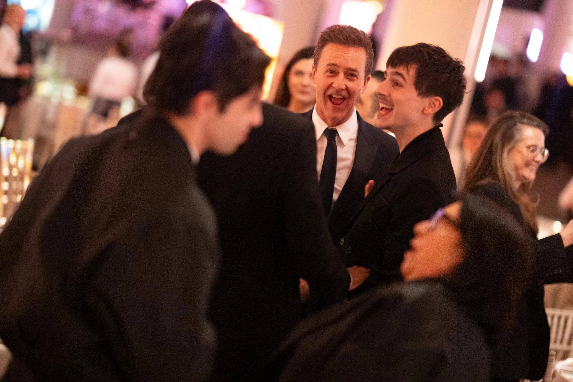 Timothée Chalamet and Edward Norton laughing together after the BAFTA Film Awards.
